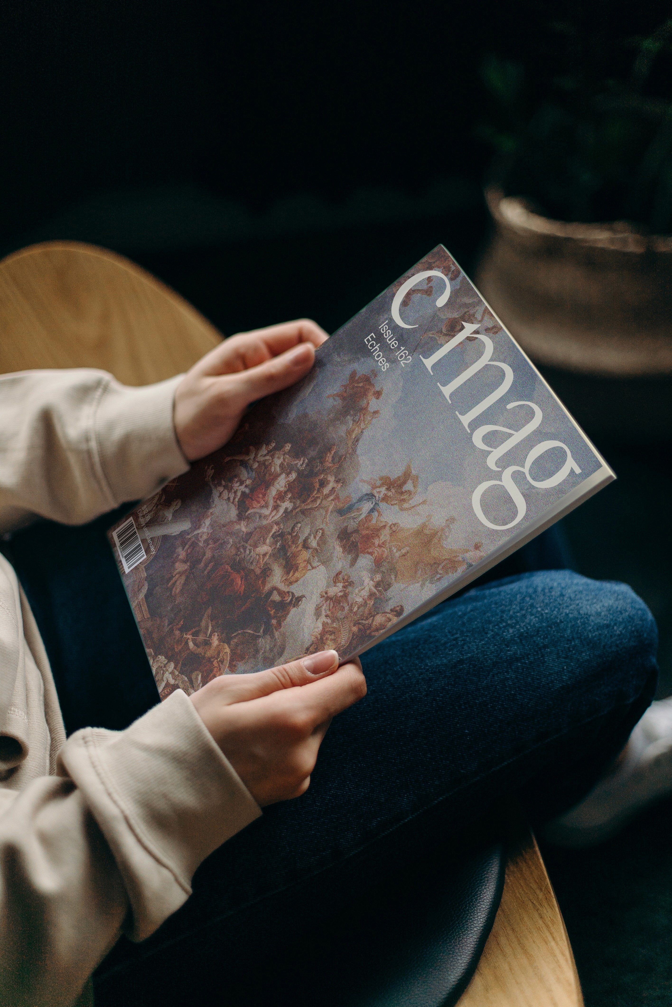 alt="Editorial magazine layout design for C Magazine held by a person"