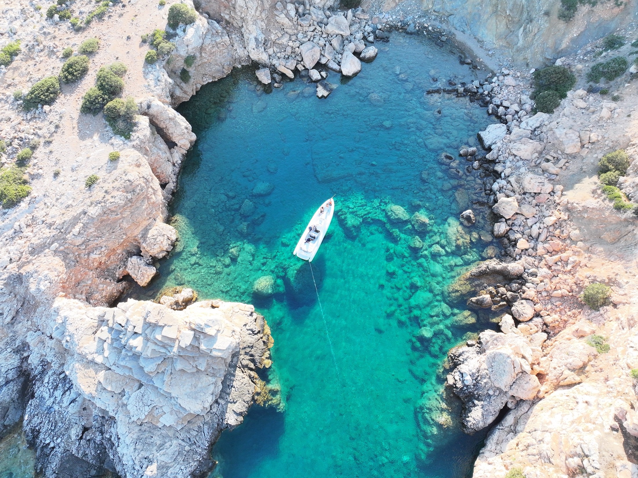 White luxury yacht Airship 30 Aether anchored in crystal-clear turquoise waters, aerial view showing pristine seabed beneath.
