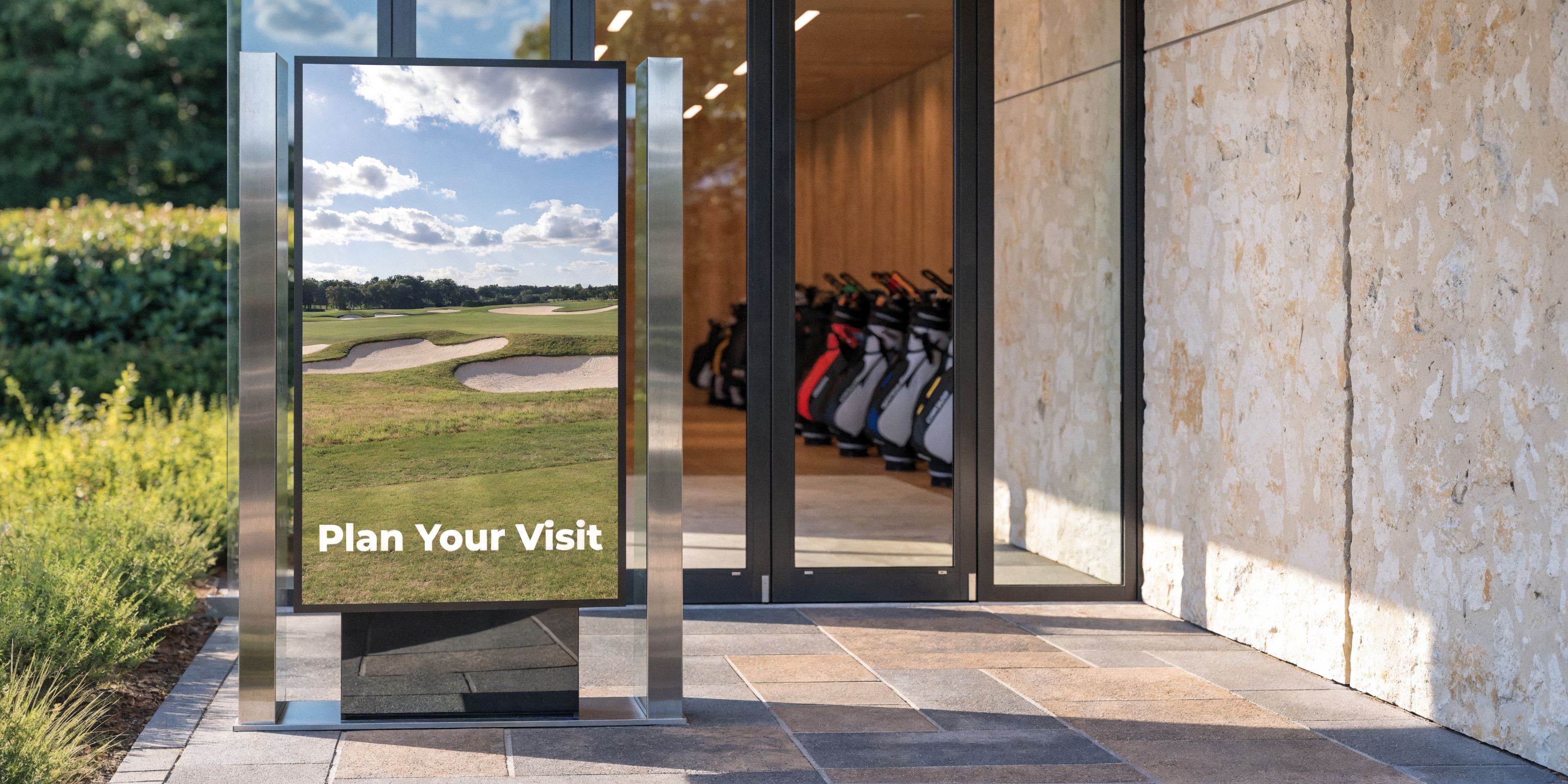 A sleek digital information board displays a golf course scene outside a modern clubhouse entrance.