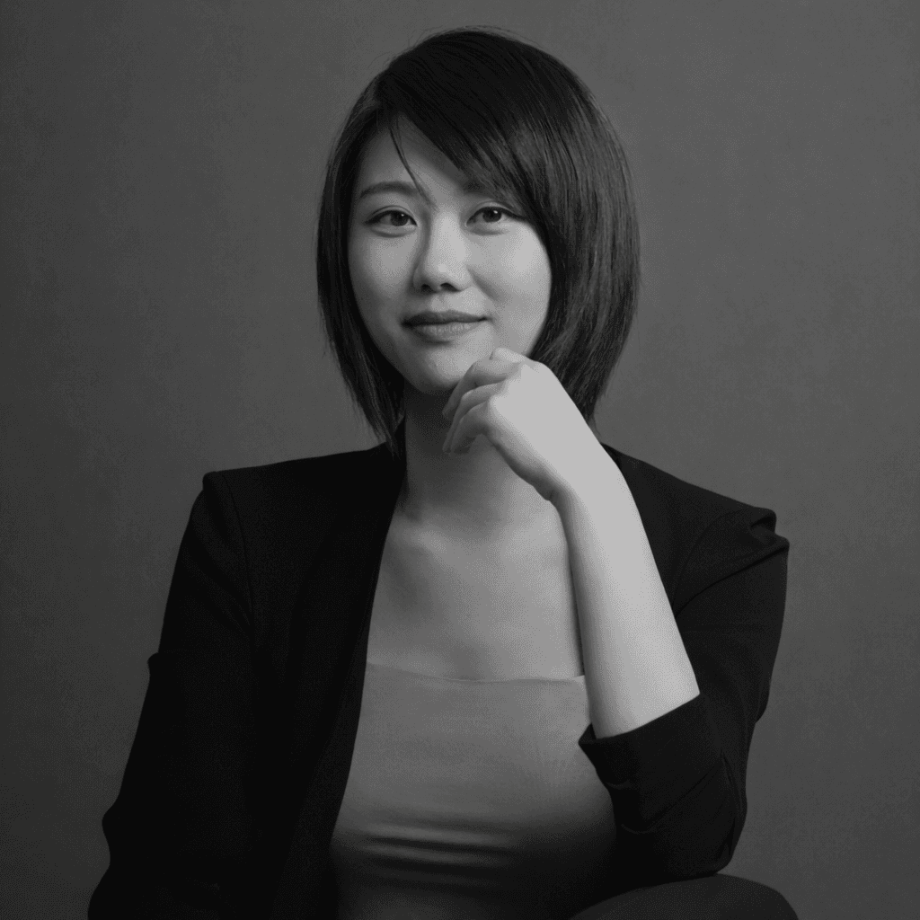 Woman in a light suit sitting thoughtfully against a terracotta wall