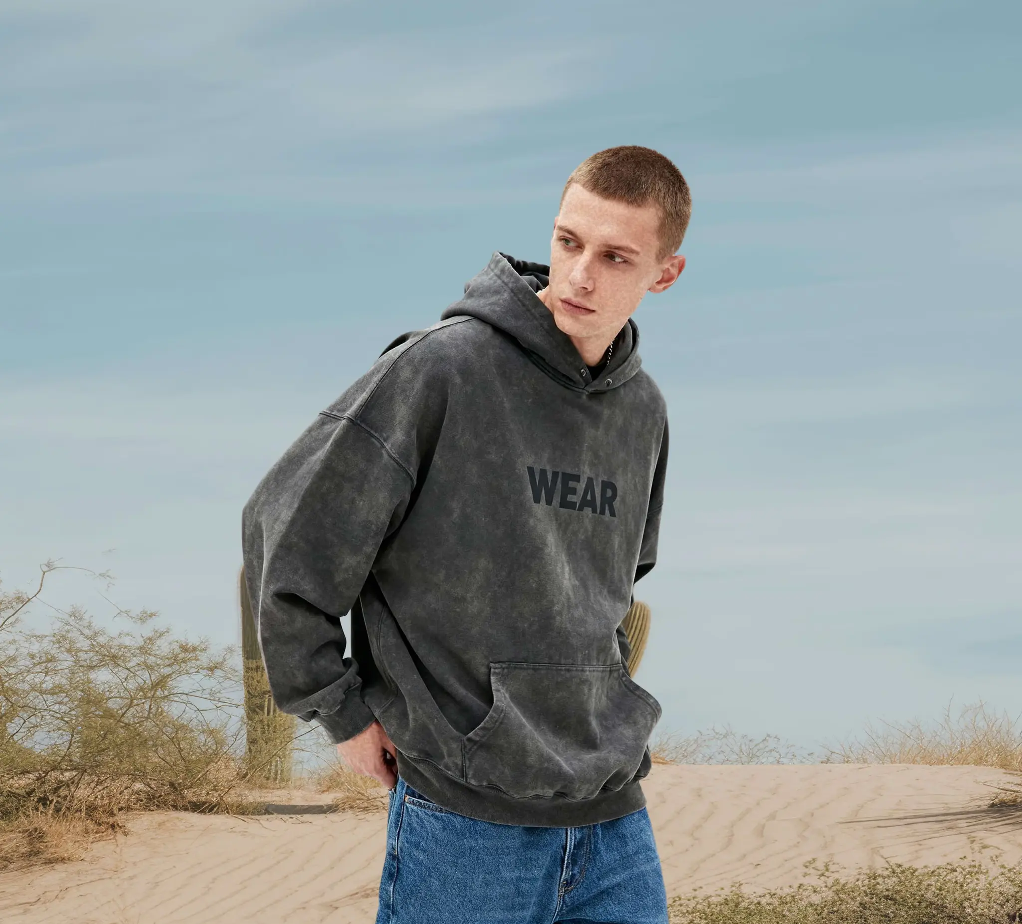 Male model wearing a gray hoodie, facing forward.