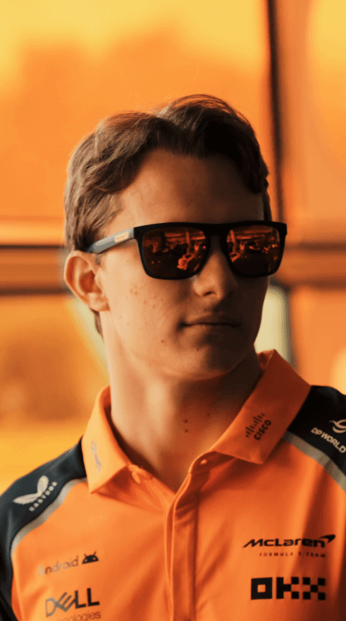 Three models standing in a wheat field, wearing beige suits.