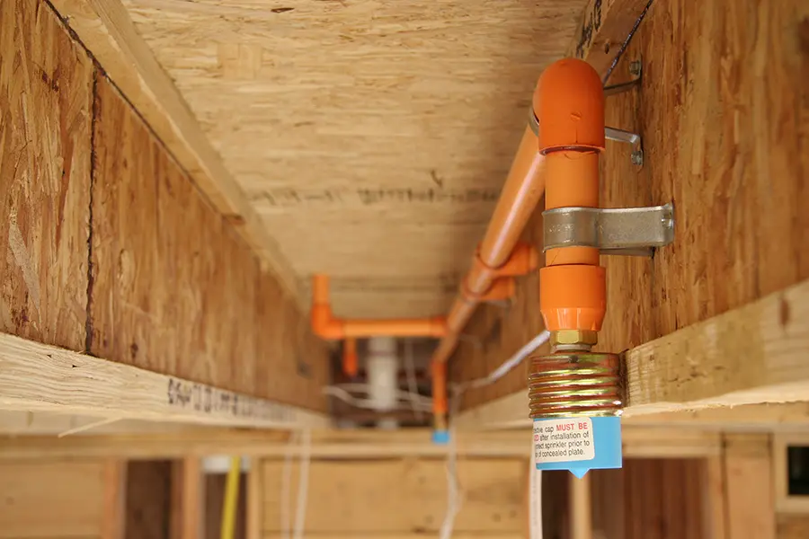 CPVC fire sprinkler piping installed along attic framing prior to spray foam insulation installation
