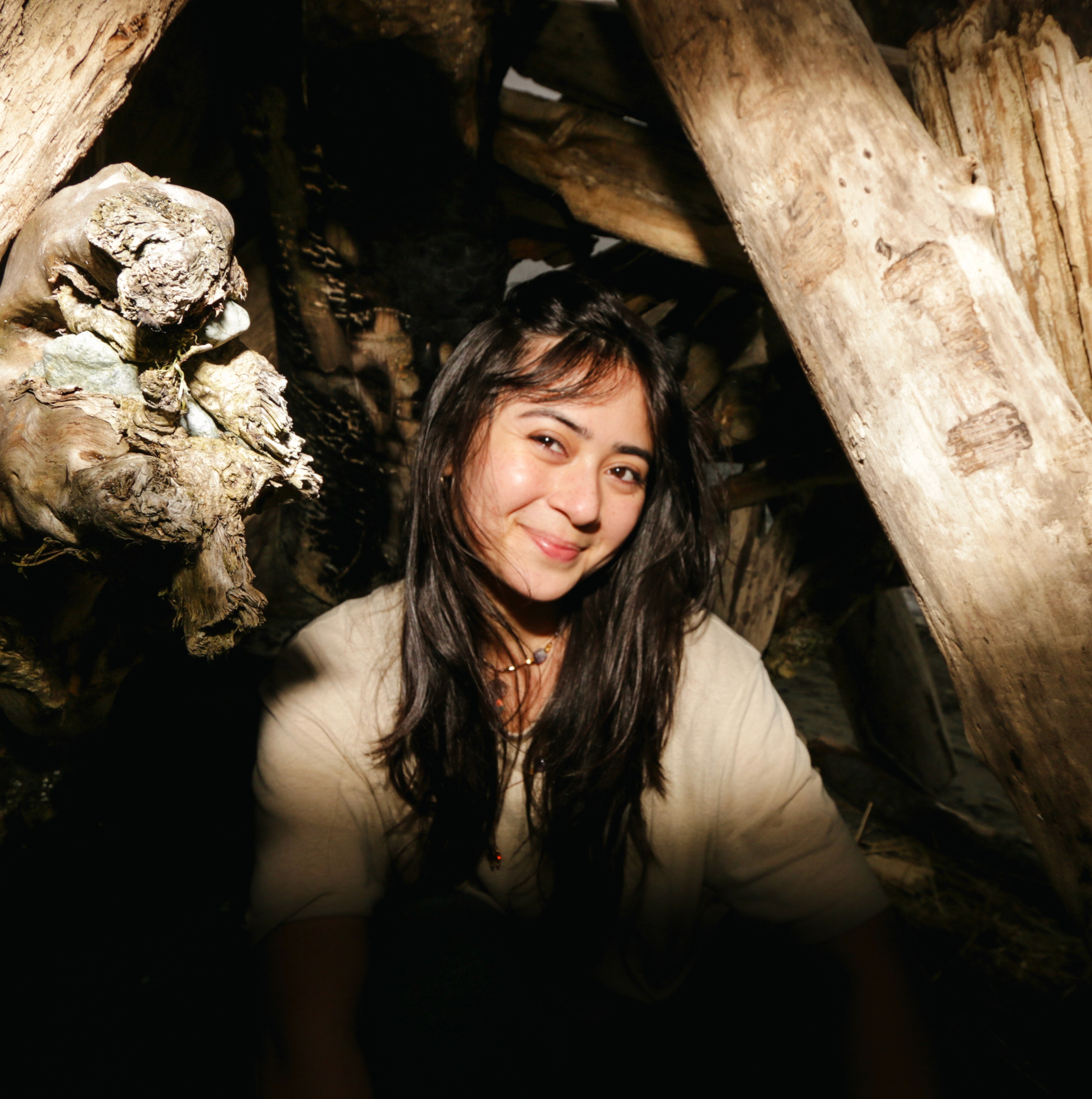A thoughtful young person with dark hair gazes to the side, captured in soft black and white lighting.