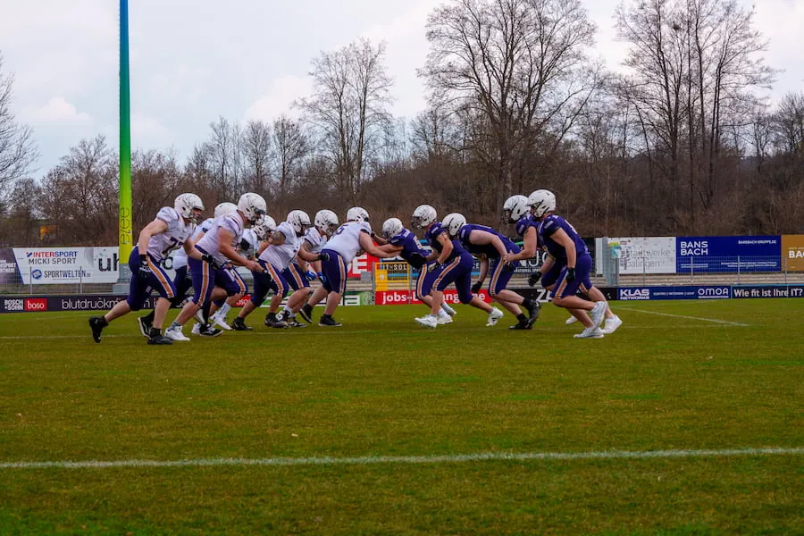 Offense und Defense der Bucks stehen sich an der Line of Scrimmage gegenüber, im Hintergrund kahle Bäume.