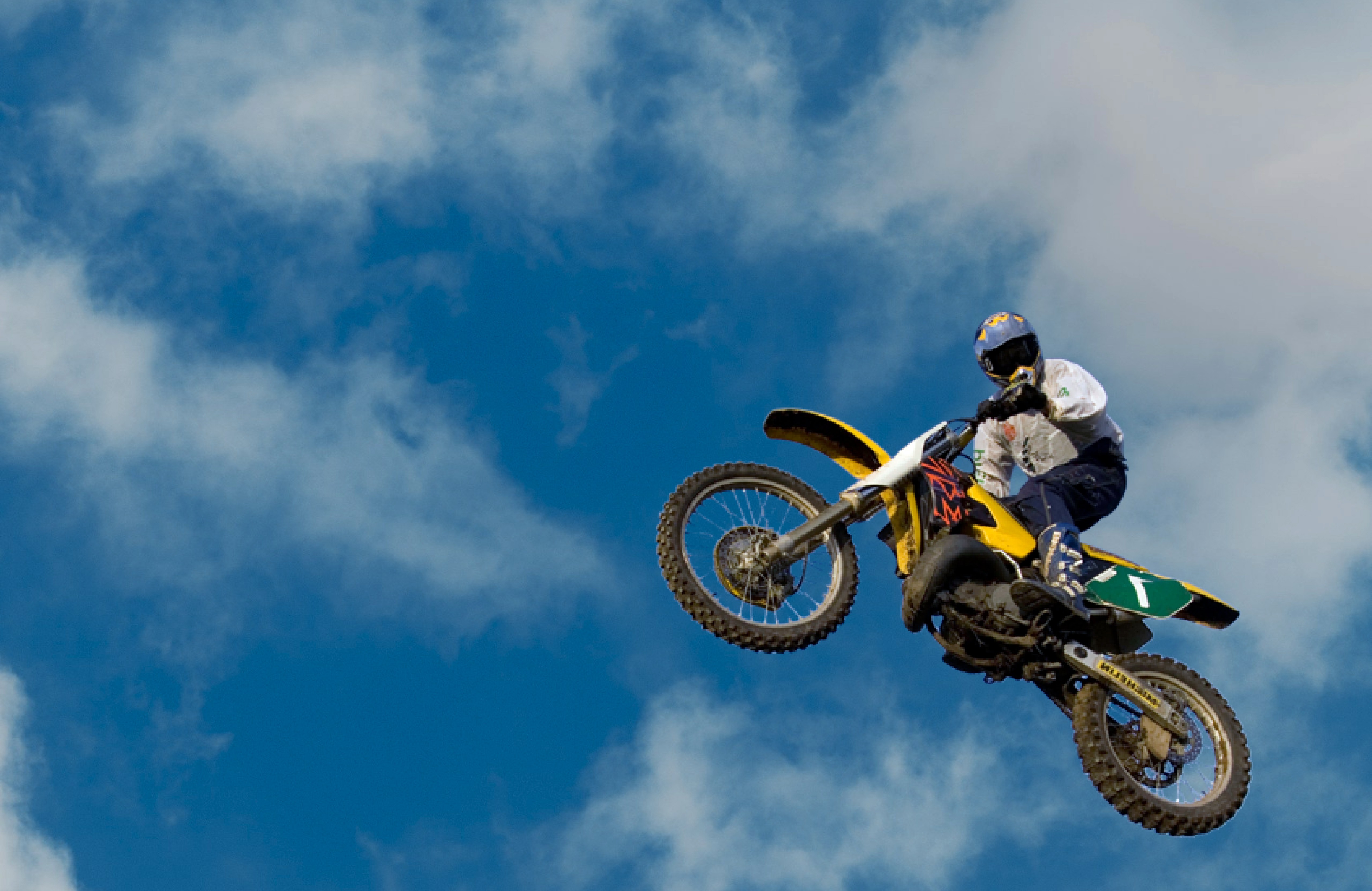 Two individuals are working out in a gym, focusing on dumbbells and strength training equipment.