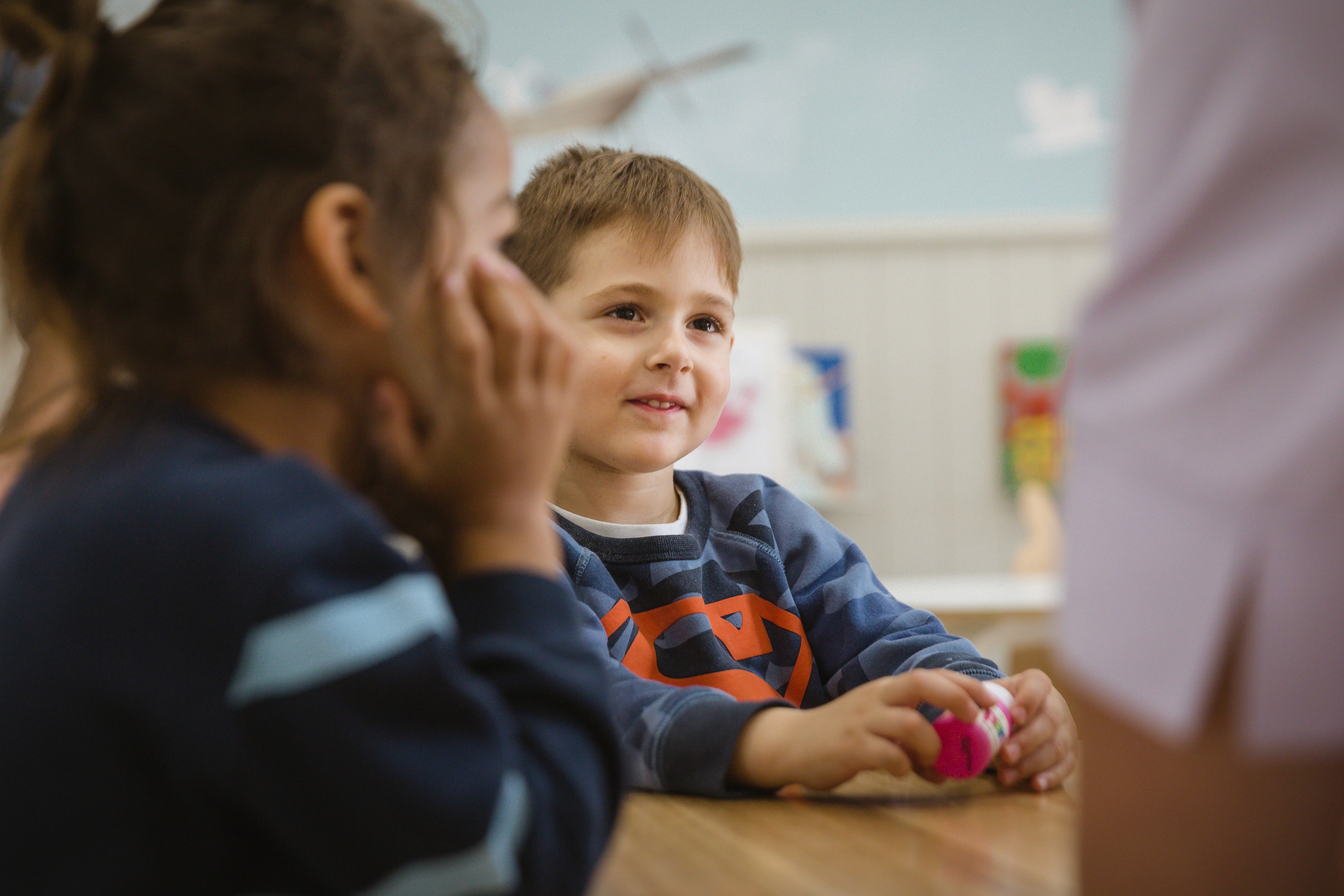 Close-up of a dark green leaf showing its textured surface and central vein against a muted background.