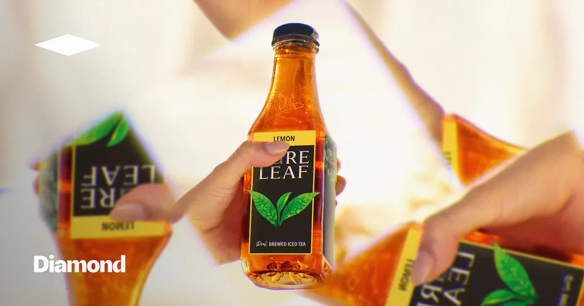Hand holding a Pure Leaf tea bottle with mirrored reflections around it