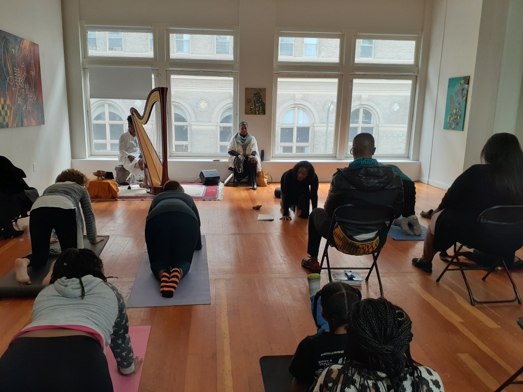 A group of four people engaged in a discussion while seated in a cozy, plant-filled setting.