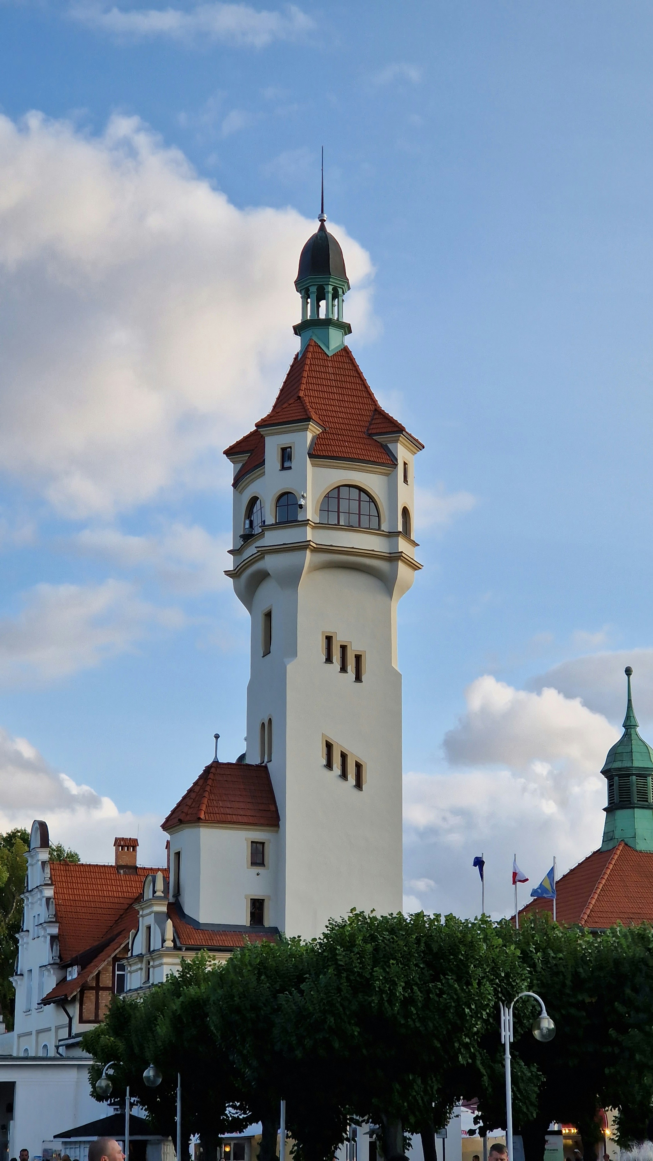 A tall white tower with a clock on it's side