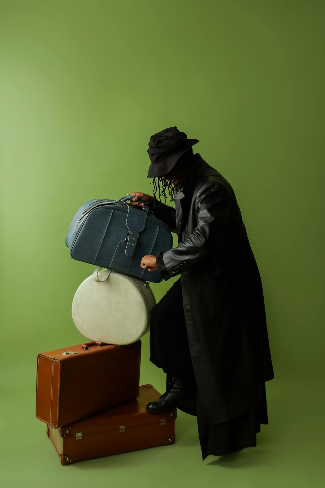 Fashion portrait of a man with black coat next to luggages