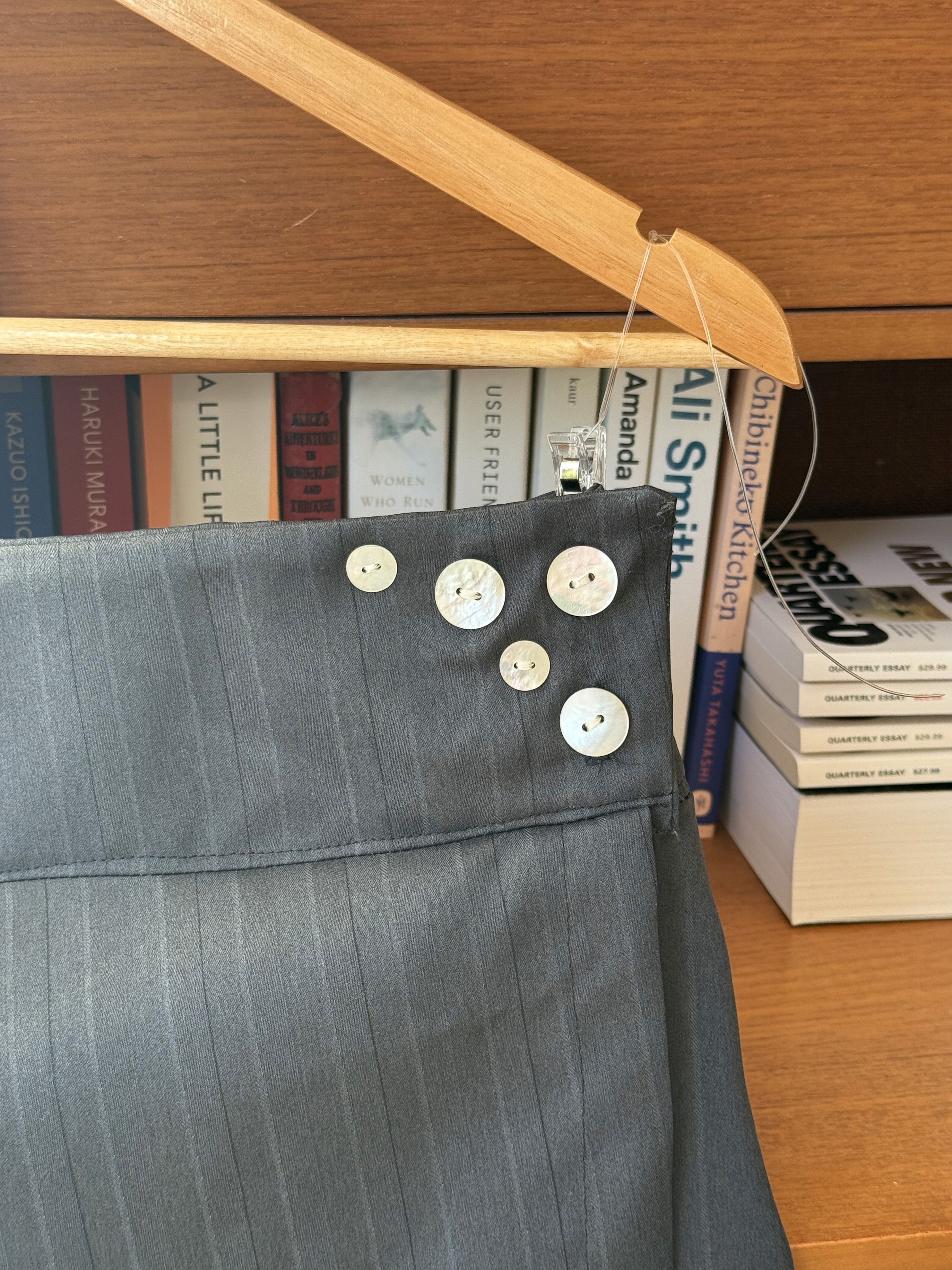 Close-up of black pinstripe short skirt with buttons 