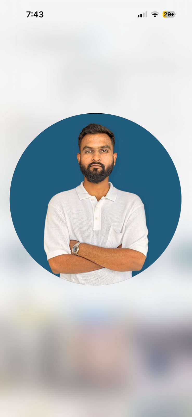 A person on a white shirt and black coat standing at the window indoor of the office