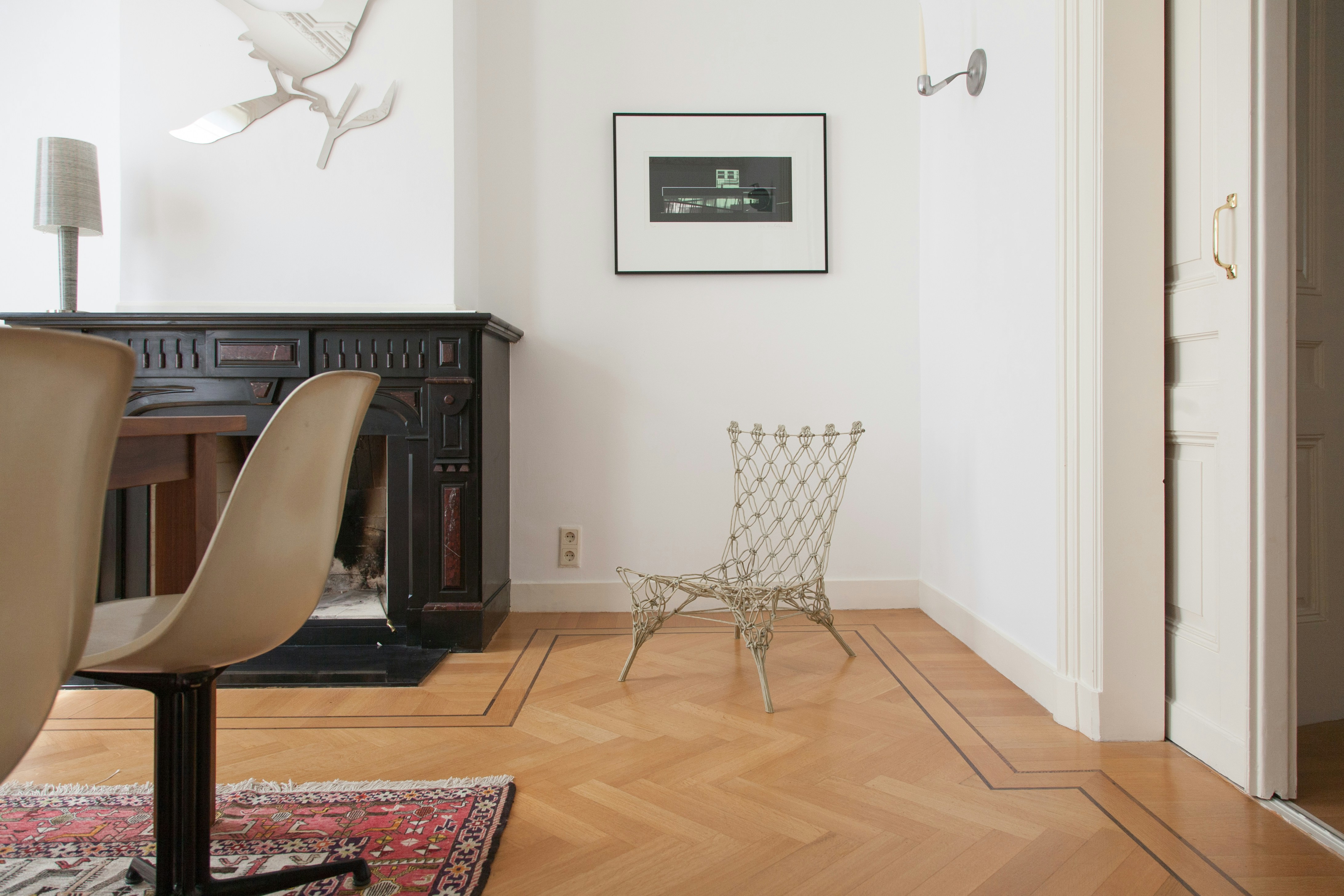 hardwood floor with chairs, rug, painting on the wall
