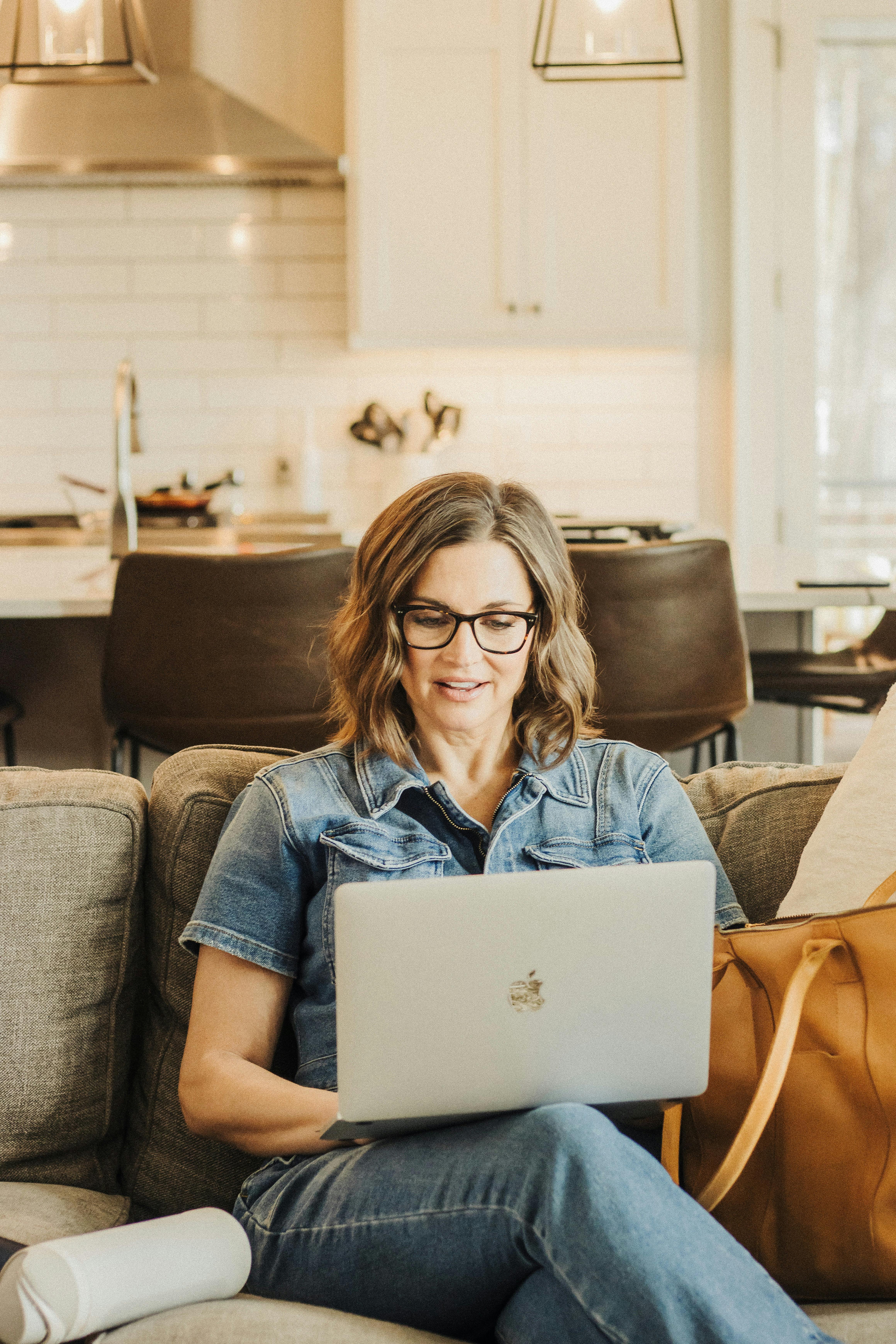 Professionista al laptop sul divano: formazione online flessibile da casa