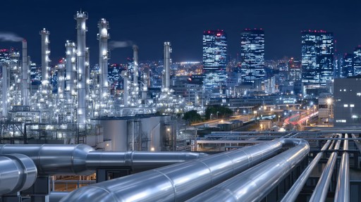 Pipelines extending through an urban landscape at night, representing the energy sector.