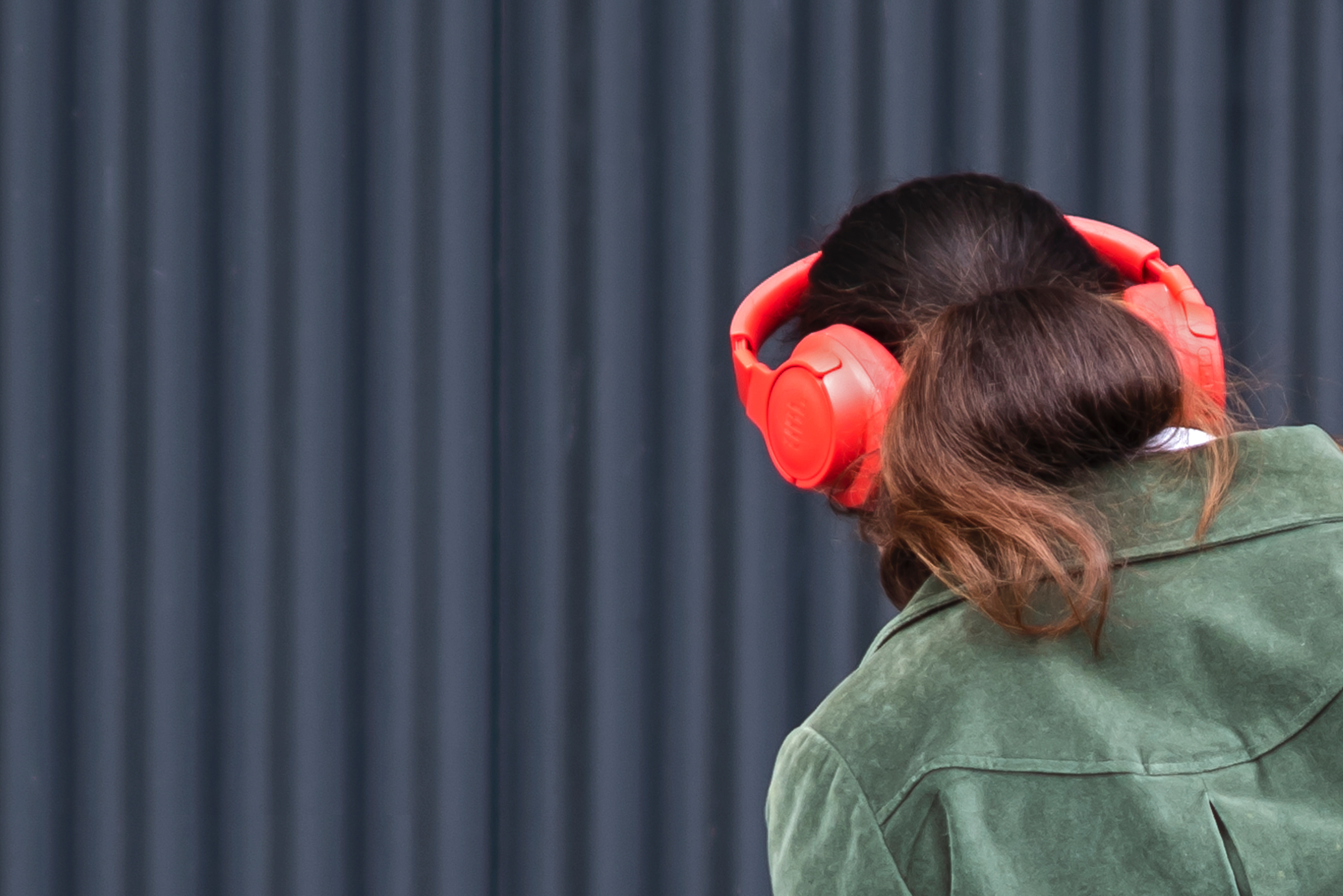 Woman with orange headphones listening to music - splash pro vs musicfy