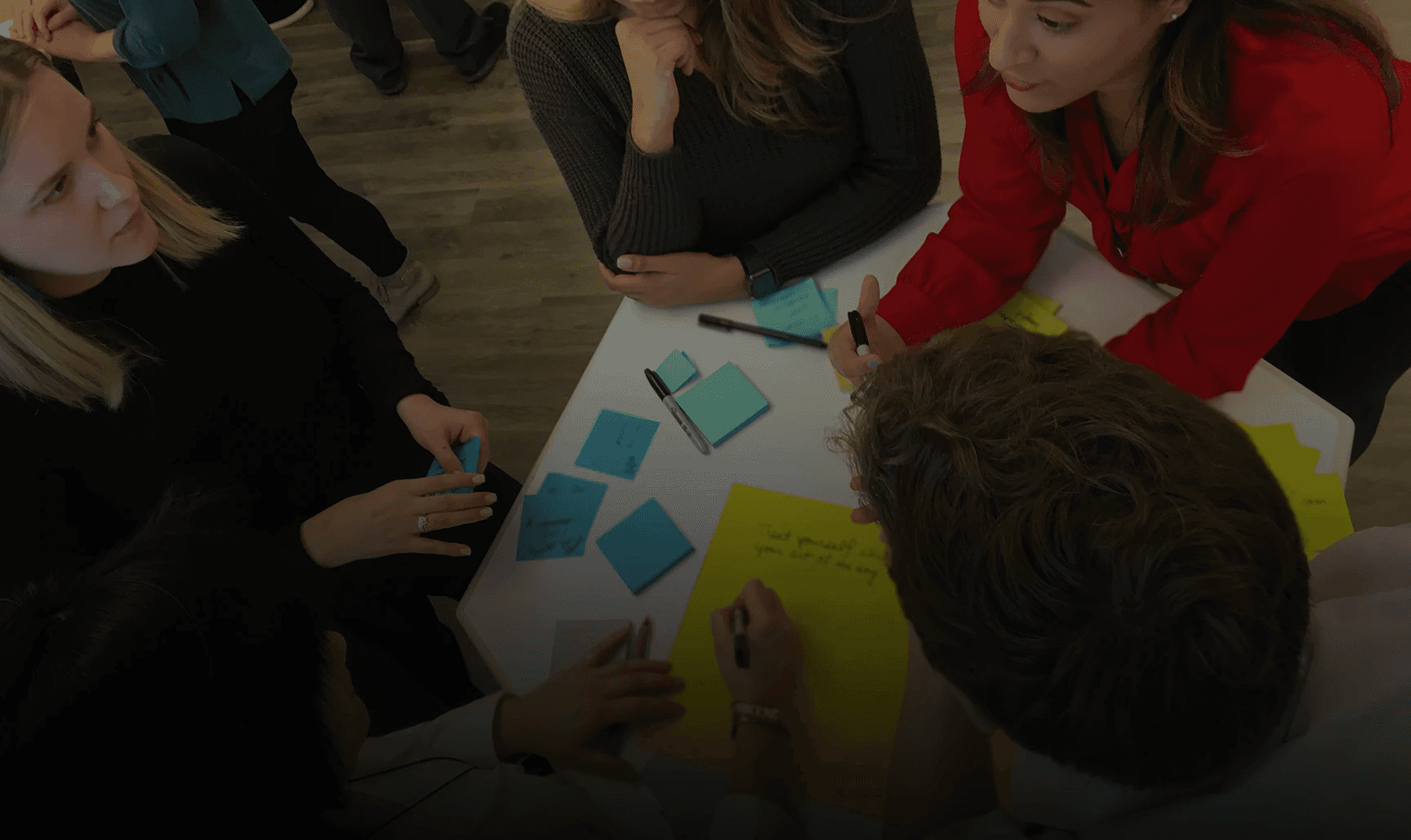 Leaders gathered around a table during a Public Works Tools & Tactics session, collaborating in a human-centered design session to strengthen organizational agility.