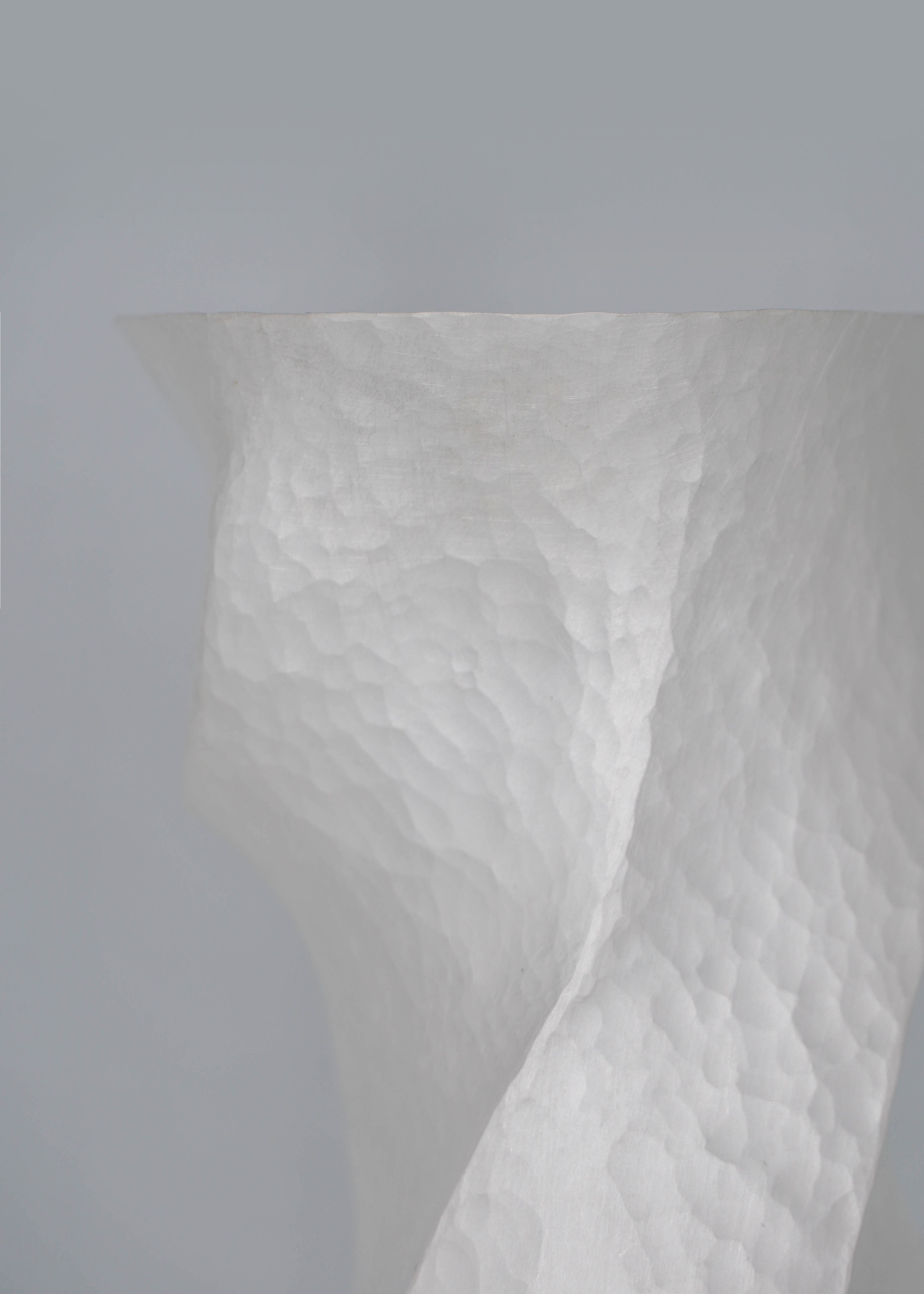 Close-up of Constrict by Yuxin Song, hand-forged fine silver vase. Contemporary silversmithing and metalwork by artist Yuxin Song