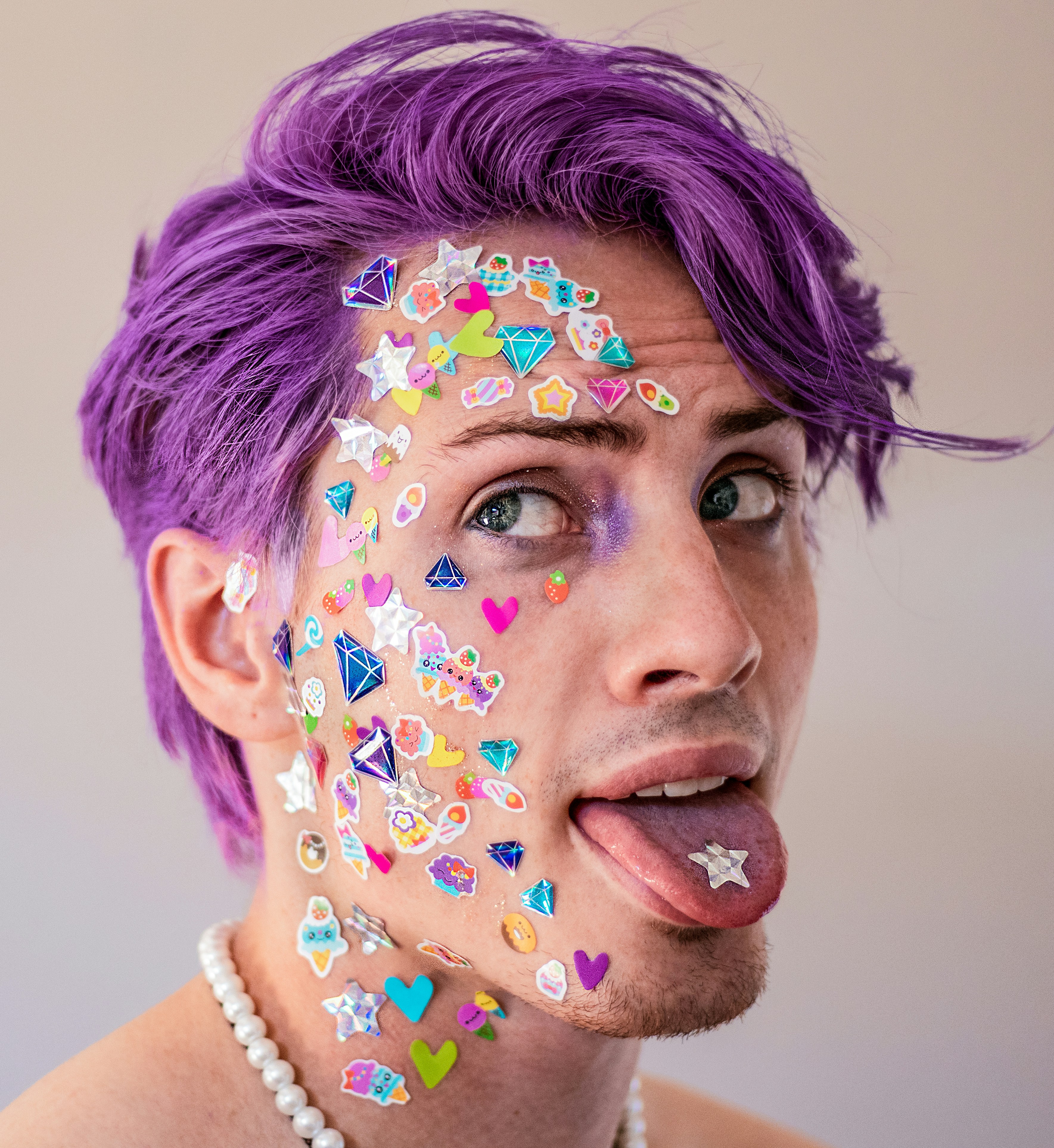 male-read person with purple hair and stickers on the face