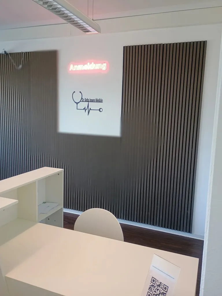 Patient at reception desk in a medical office, talking to receptionist.