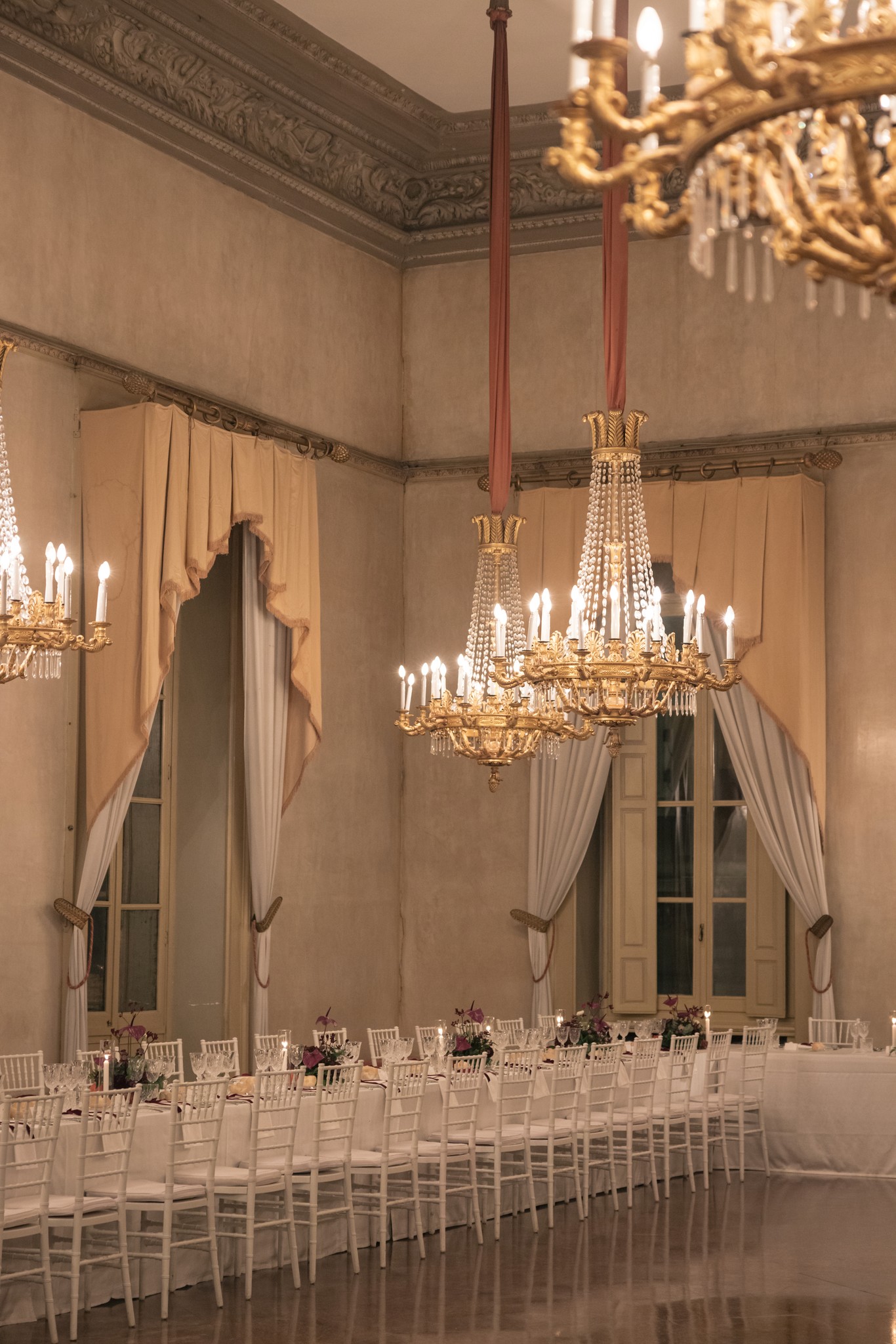 Sala ricevimento matrimonio al Circolo di Lettura a Parma, tavoli bianchi e lampadari dorati sotto soffitti affrescati