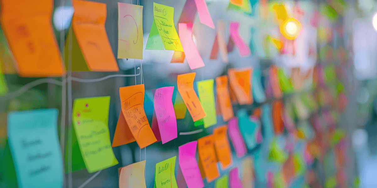 Colorful sticky notes on a glass wall, creating a vibrant and creative workspace atmosphere.