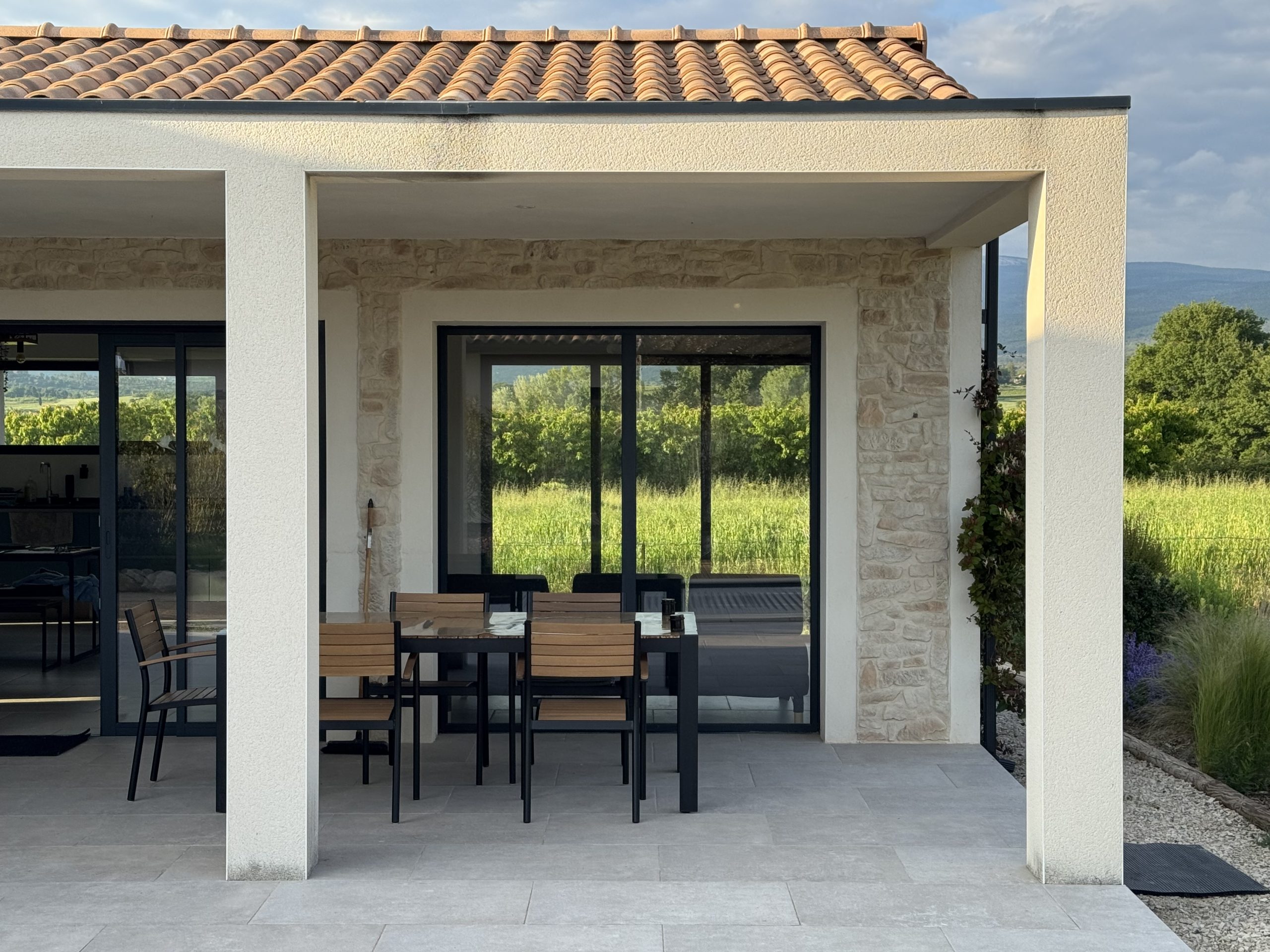 Maison contemporaine avec terrasse et vue sur la campagne. Architecture moderne, design extérieur.