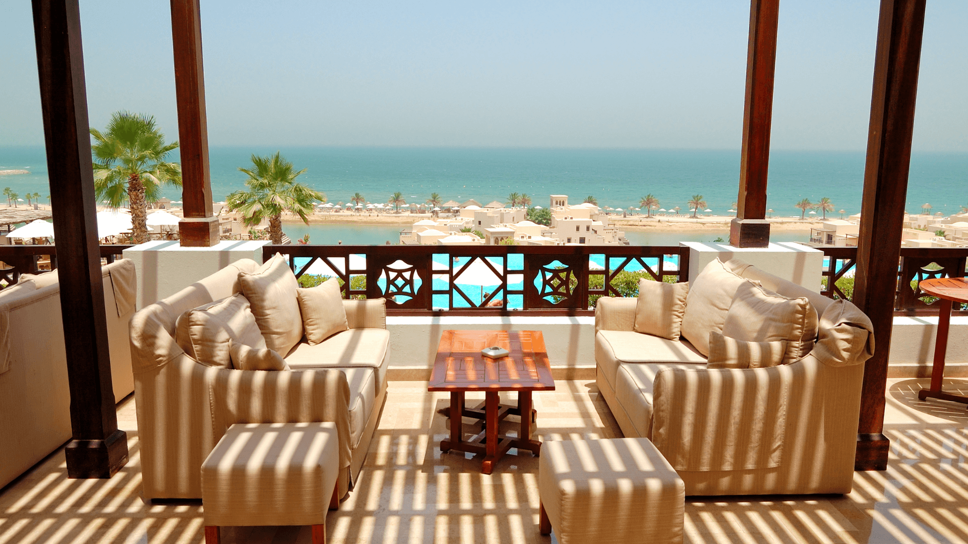 Elegant seaside restaurant terrace set for lunch with panoramic ocean view and warm daylight | Lunasole Hospitality