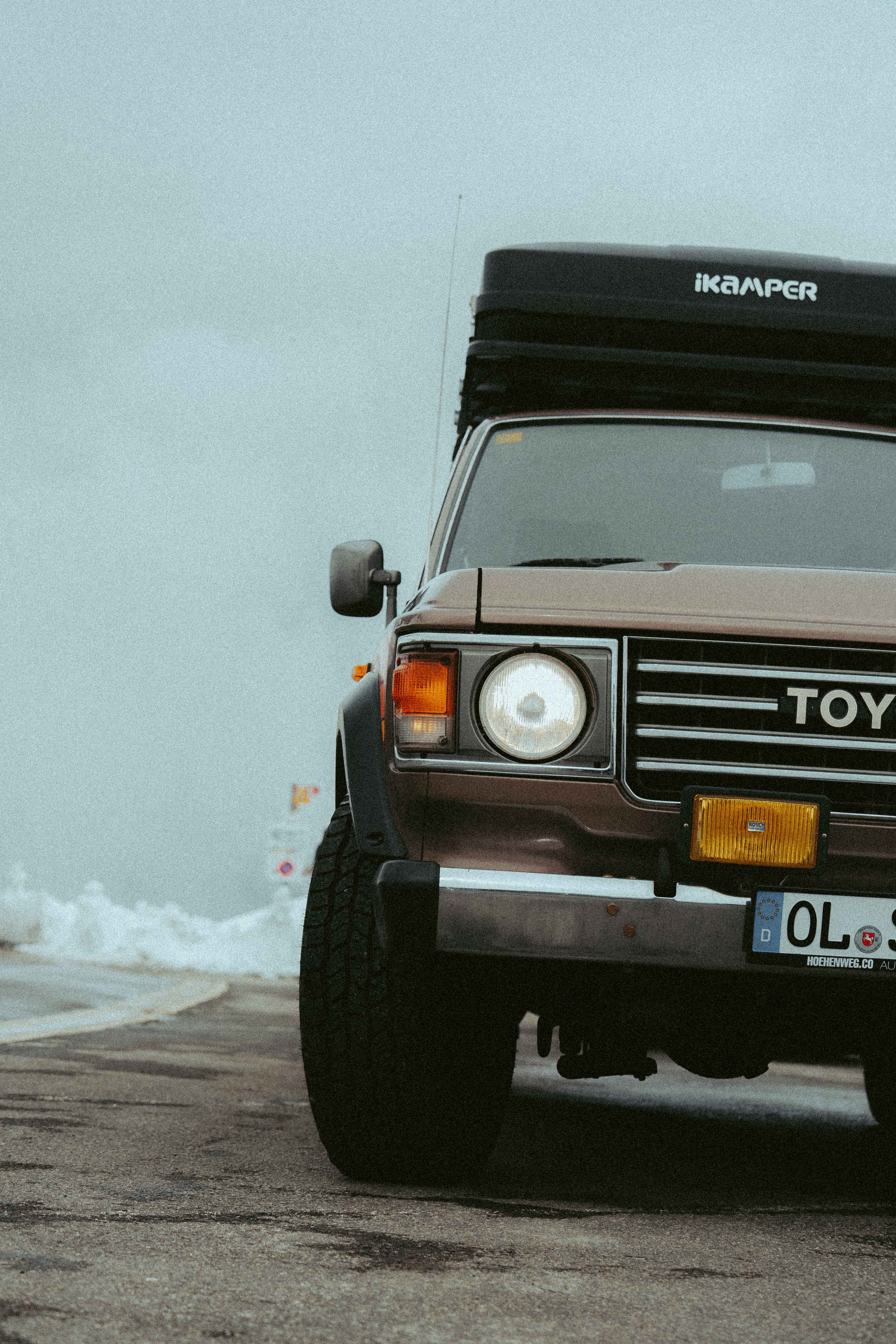 Lone traveler walking across golden dunes in AlUla desert, leaving footprints under clear morning light.