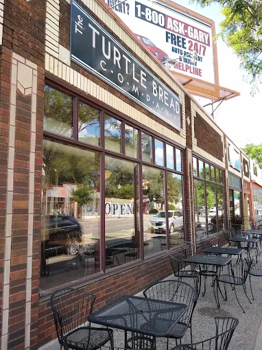 Turtle Bread Company's Chicago Avenue bakery in South Minneapolis, a brick storefront with sidewalk tables beneath the sign.