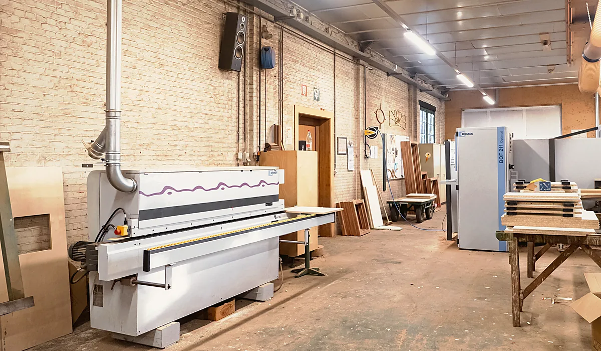 Kantenlijmmachine en machinepark in het atelier van De Houwer