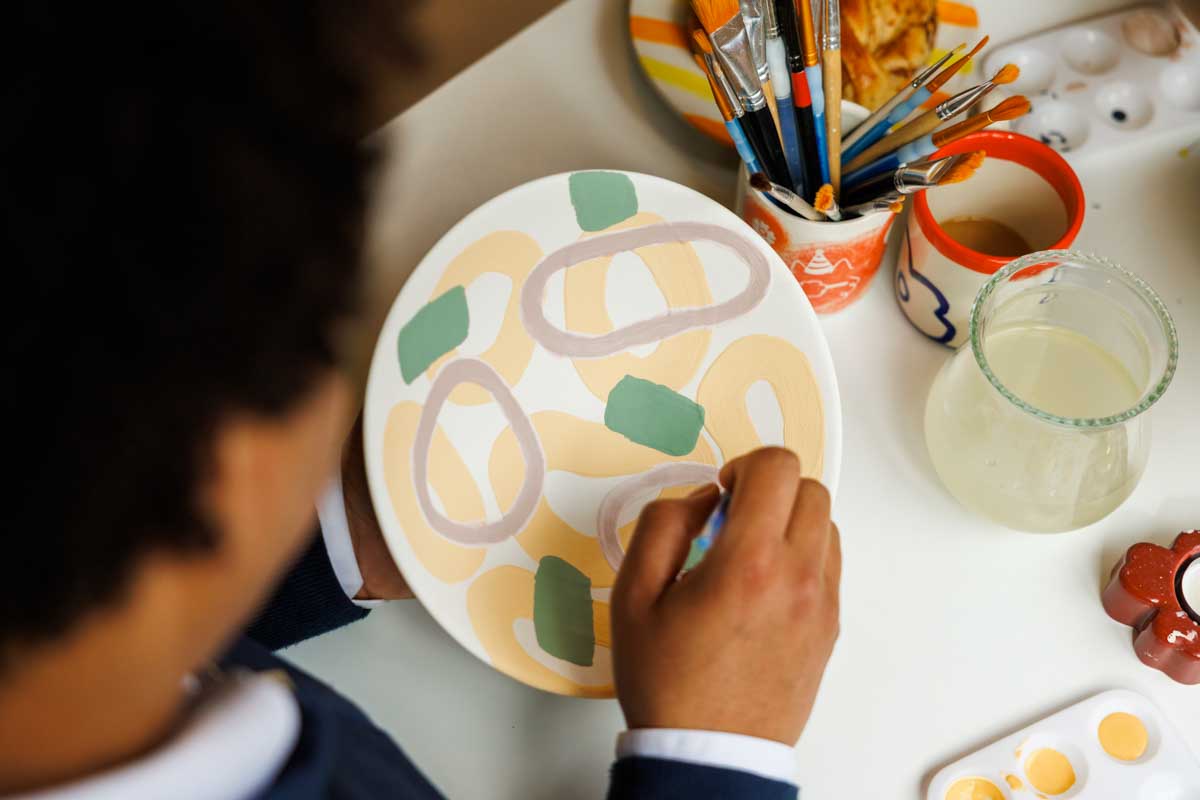 Mann som maler på keramikk