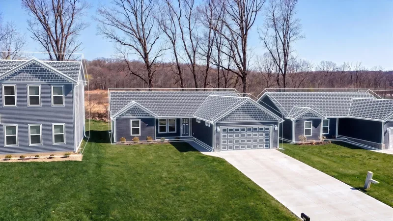 Brushwood Single-Family: navy-sided single-family homes with white wireframe lines traced over the rooflines, on new lawns with concrete driveways