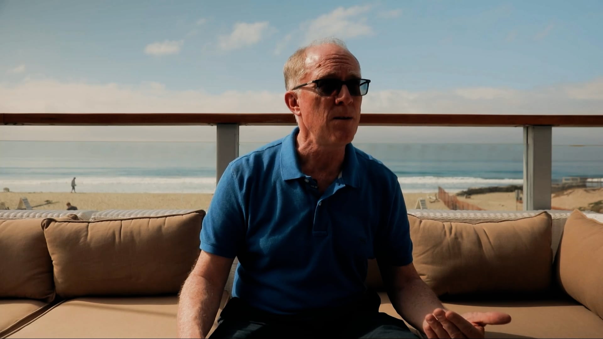 Trend Micro's Director of Customer Success sitting on a sofa in front of the beach in Malibu.