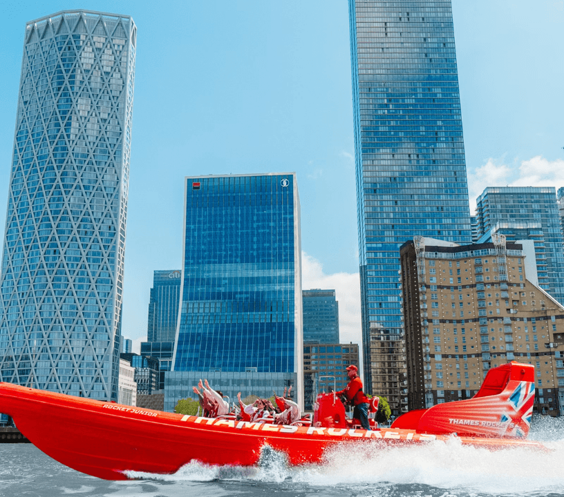 Thames Rockets Speedboat Experience: The sleek red Thames Rocket RIB speeds in front of London skyscrapers.