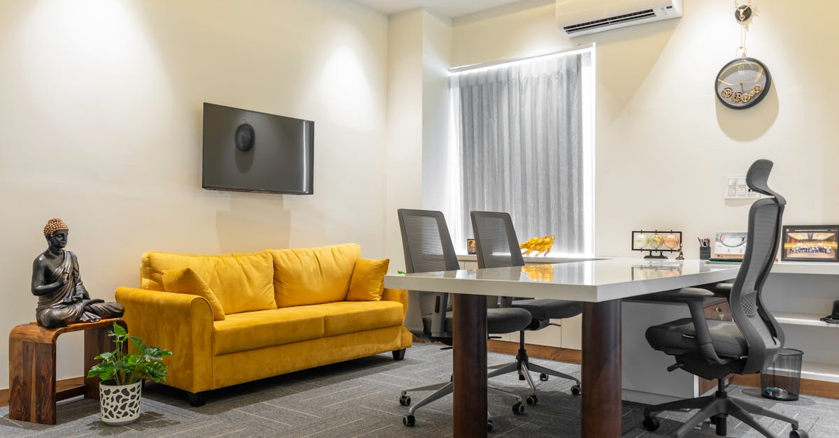 Stylish office space featuring a yellow sofa and Buddha decor in Sahibzada Ajit Singh Nagar.