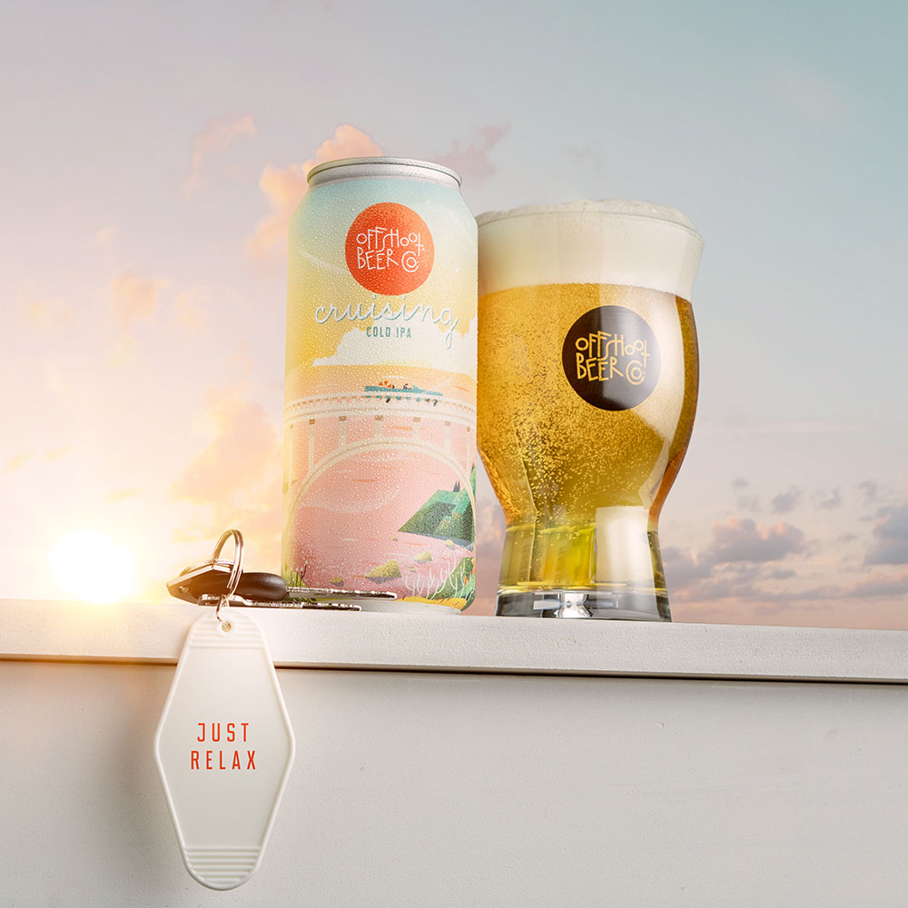 Pint glass with sunset beer can on outdoor table