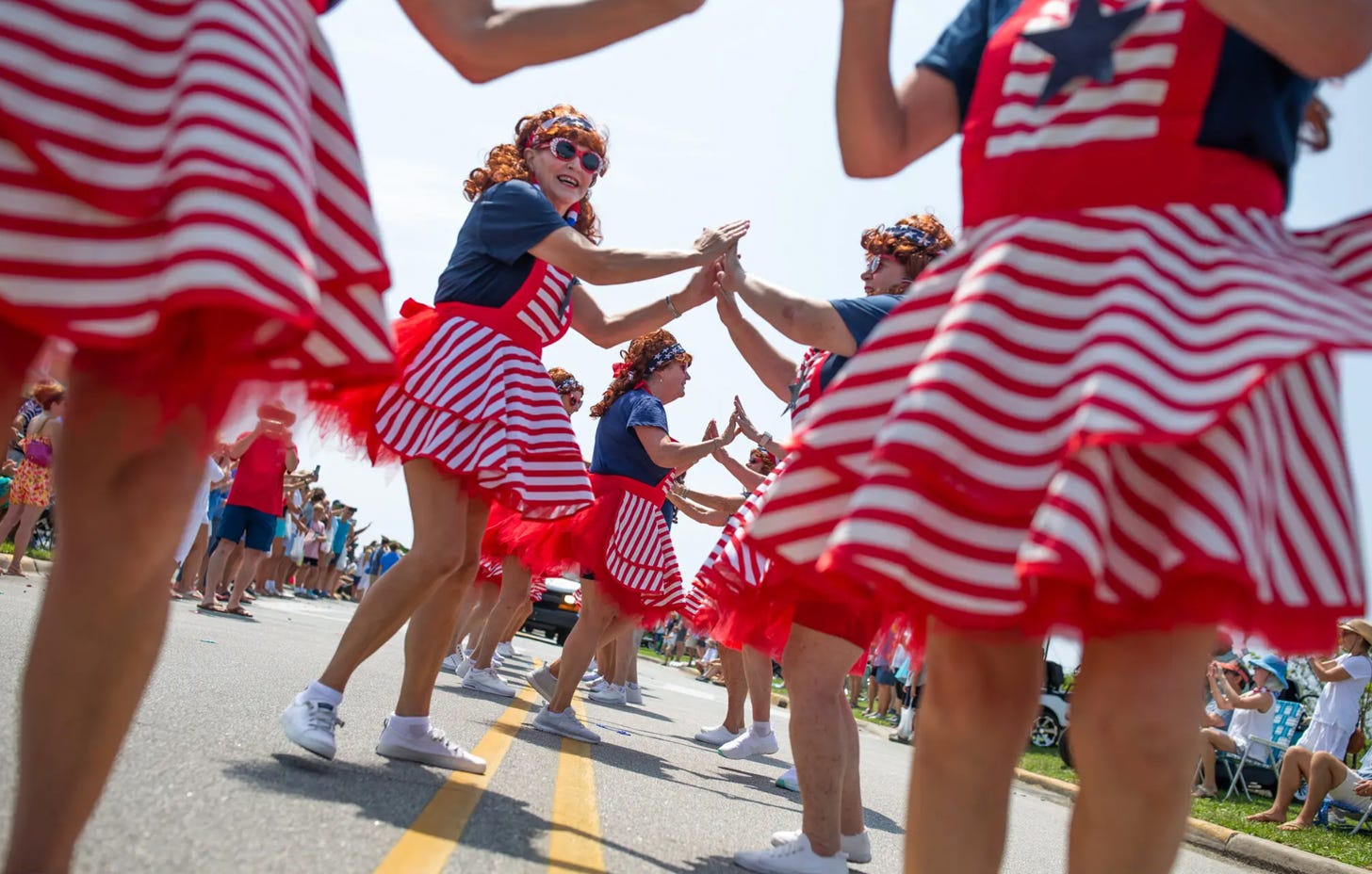 Women in red, white, and blue outfits dancing in the street for an annual Fourth of July Parade in Beaufort, N.C.