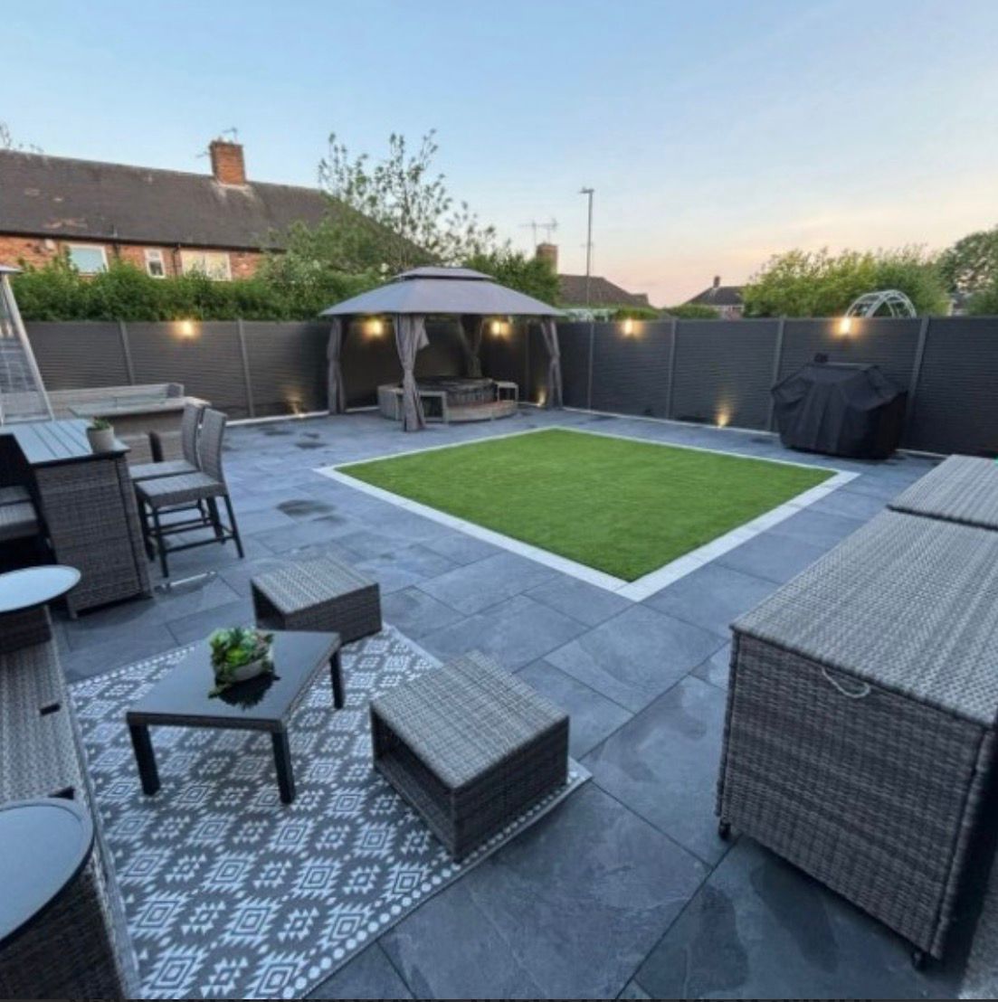 Completed garden with a central rectangular lawn, surrounding paving, outdoor seating and a gazebo.