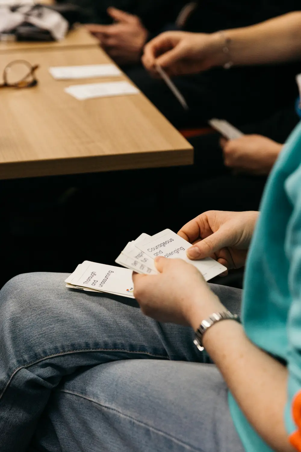 People sitting and writing in a notebook at an desks.