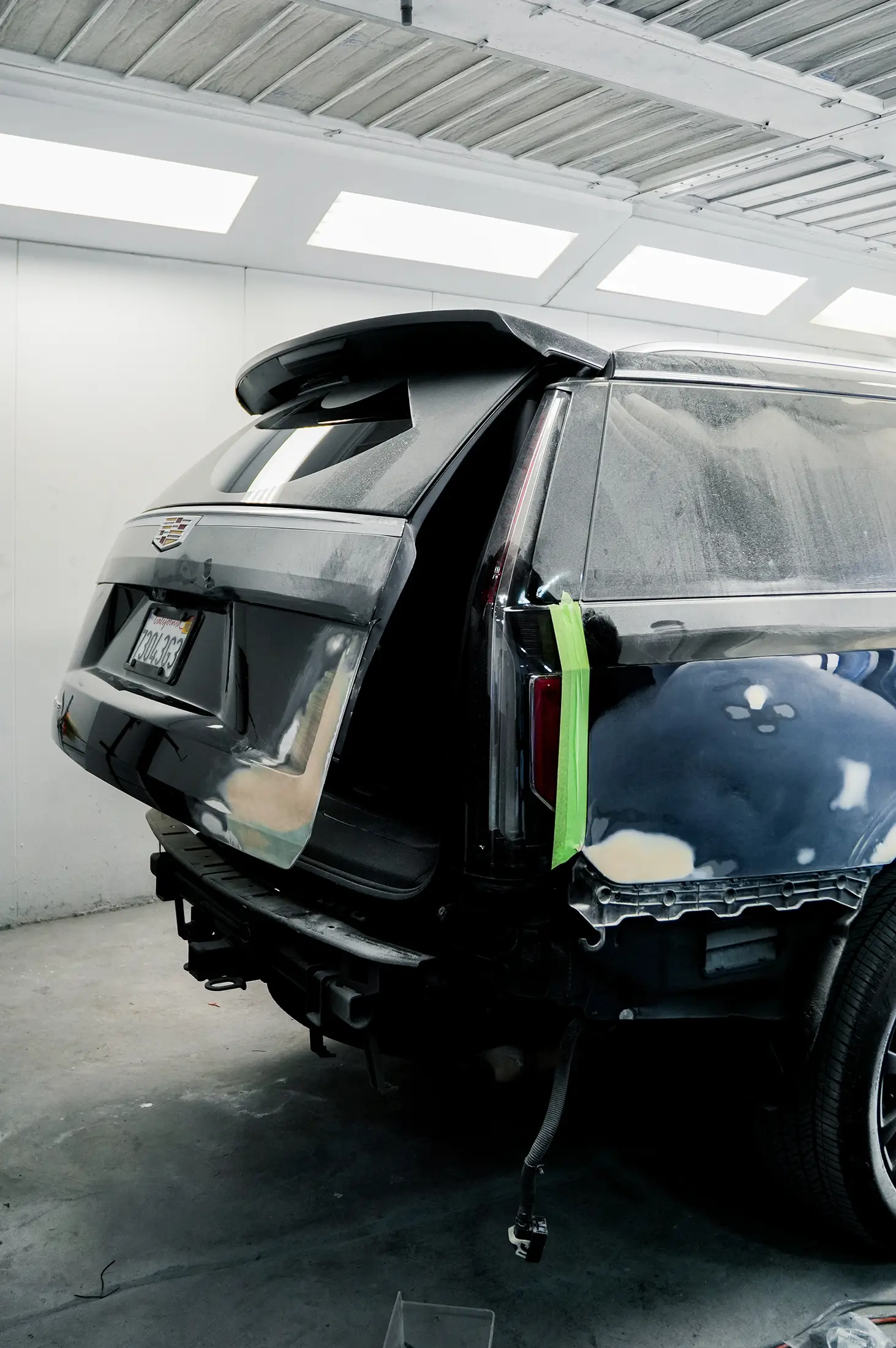 Vehicle undergoing professional paint and refinishing inside Auto Body Unlimited’s paint booth.