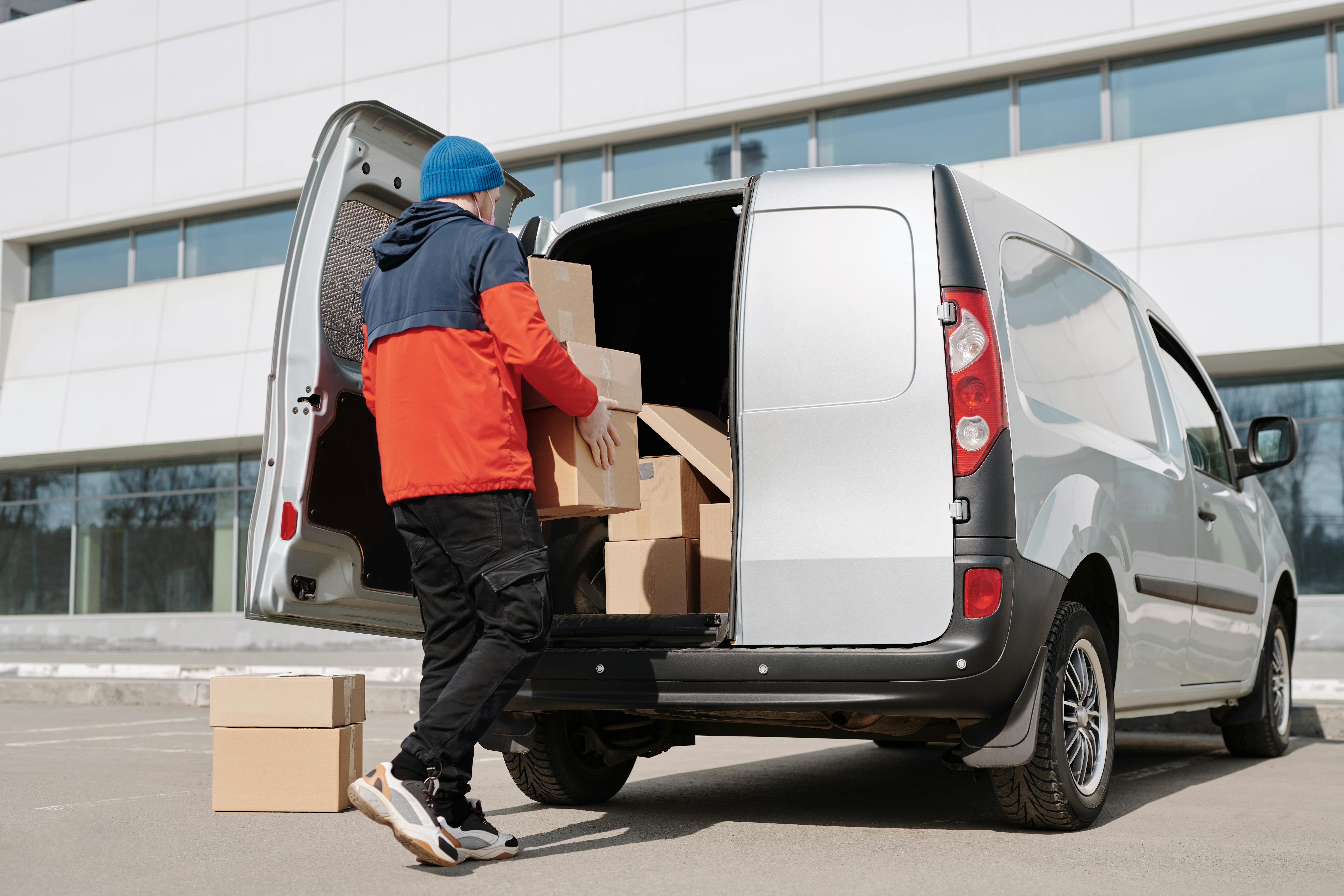 A man with moving boxes in front of a commercial property