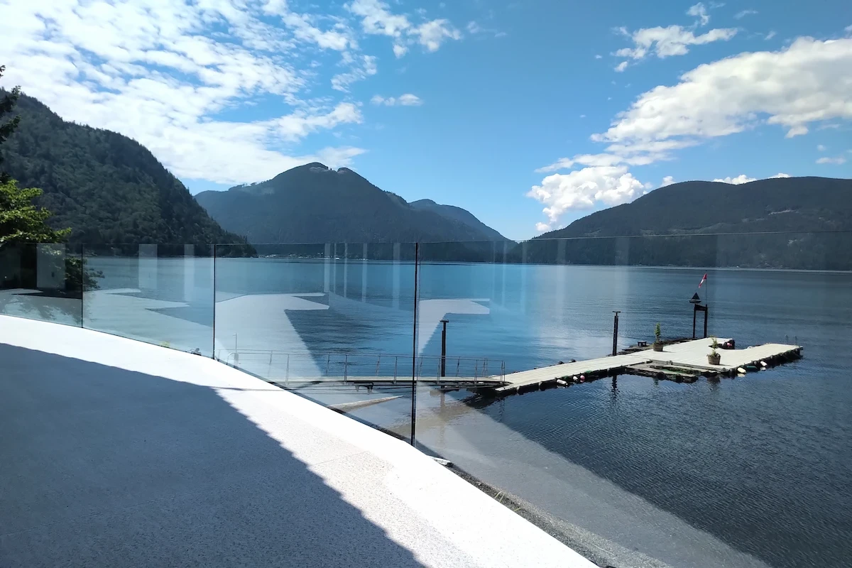 Frameless glass deck railing on coastal BC home with mountain and ocean views