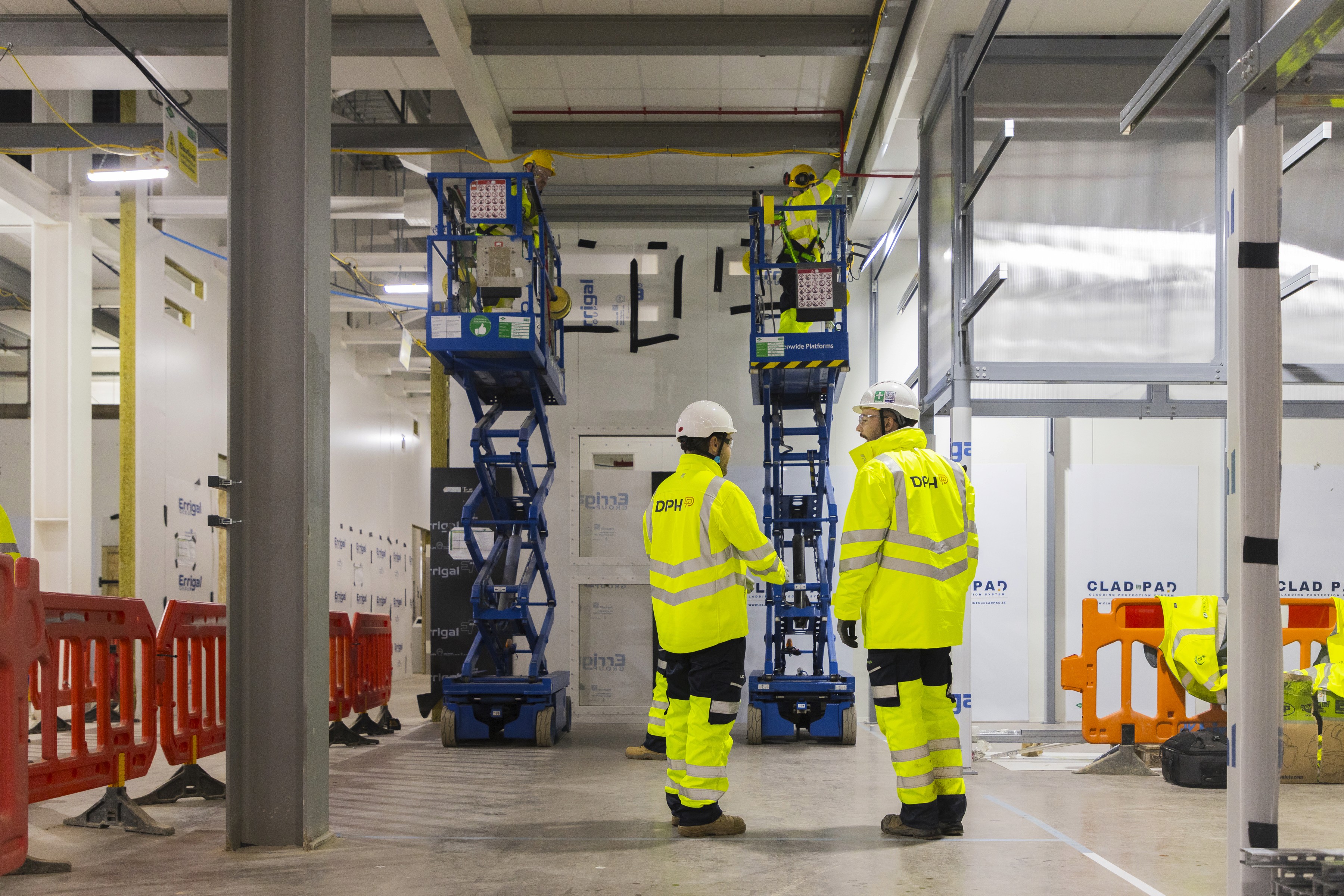 Entrance of a modern glass building with illuminated facade and reflections