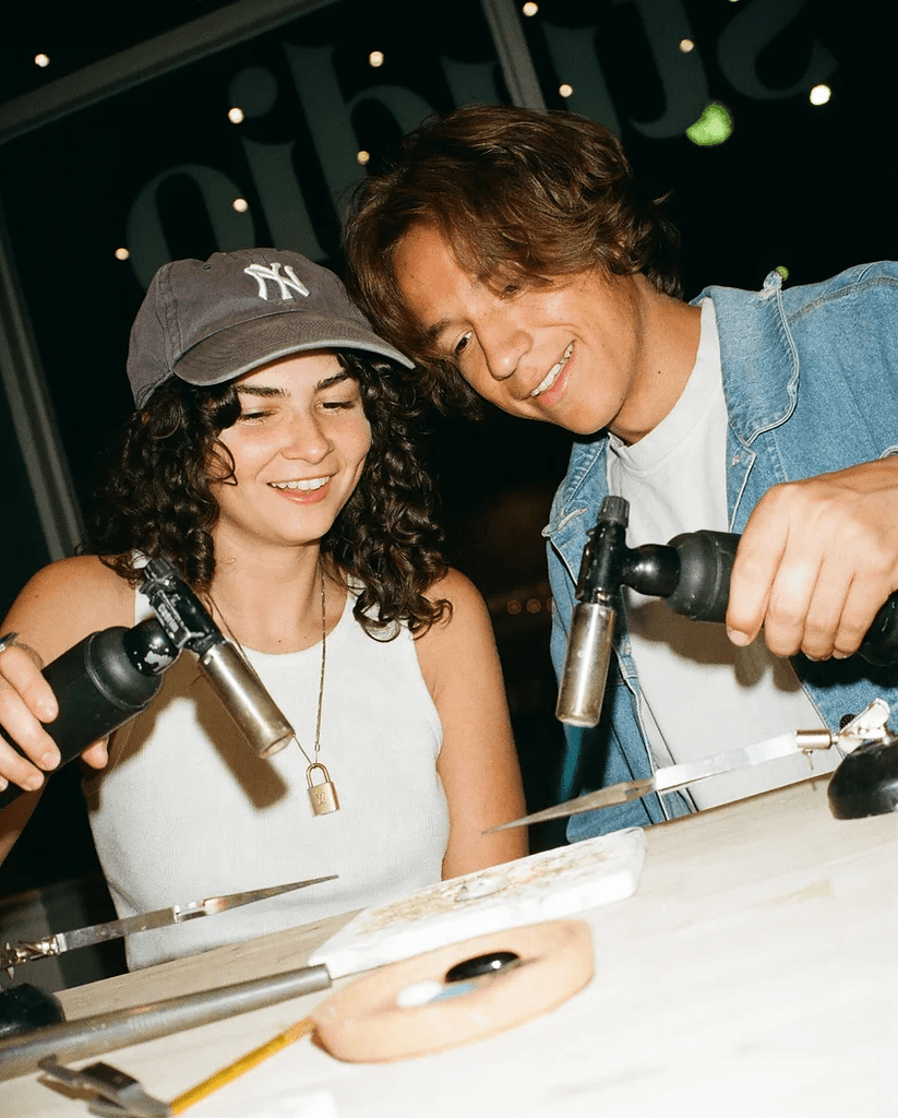 couple using a blowtorch in a jewelry workshop