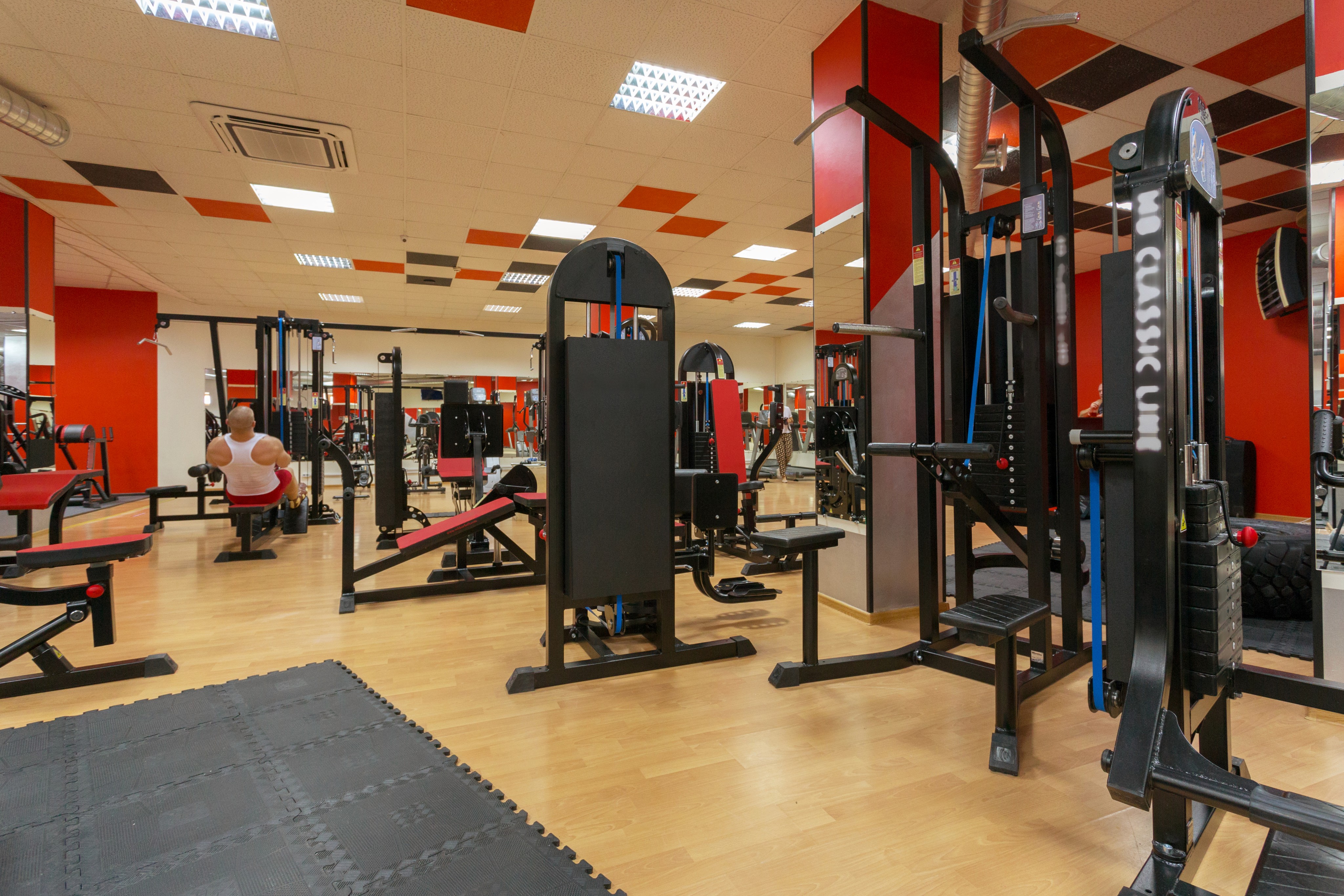 Modern gym with various exercise machines.