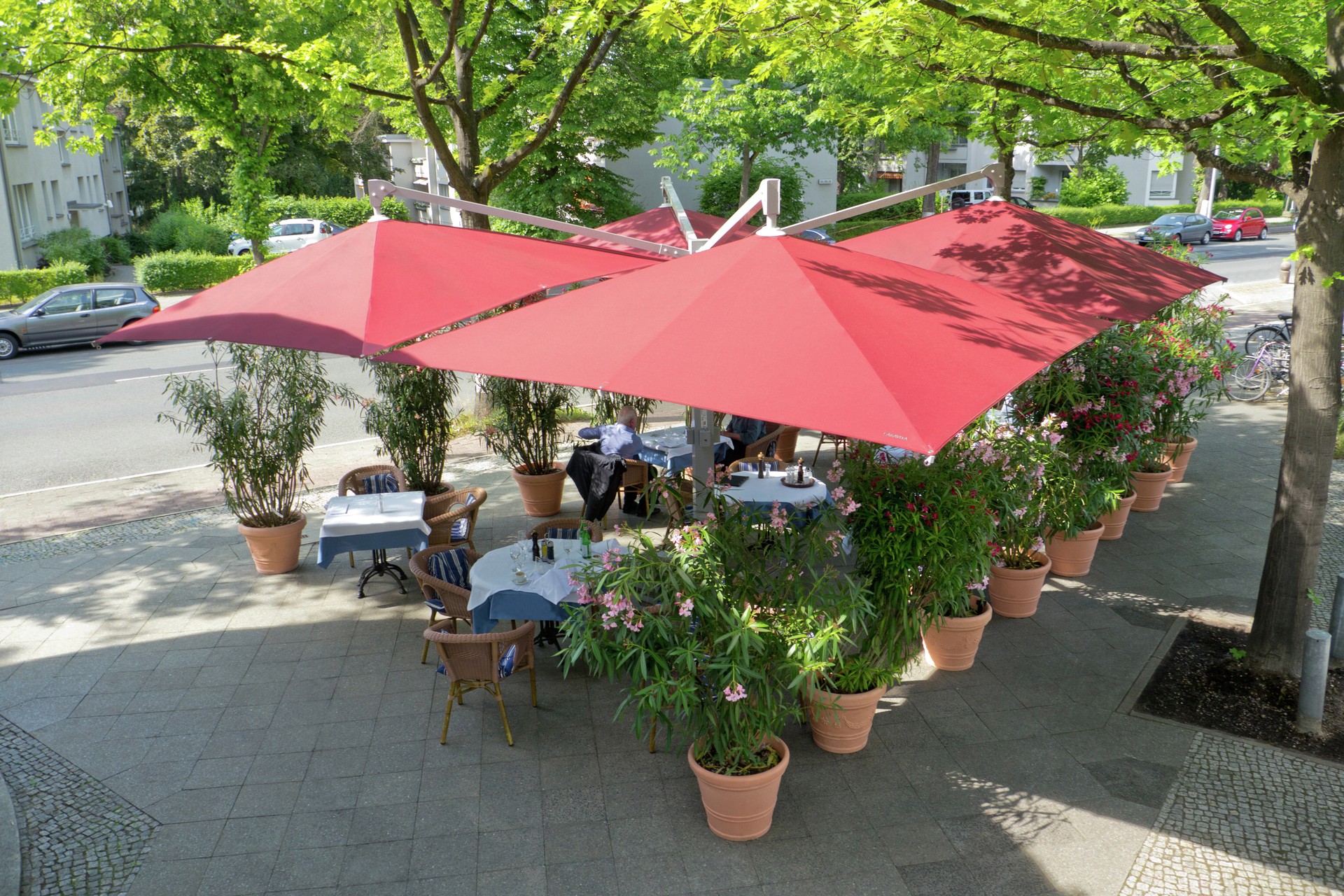 Rote Markisen spenden Sonnenschutz in einem Café in Westerwalbesloh, Gütersloh, OWL. Perfekt für Insektenschutz und Maßanfertigung im Handwerk.