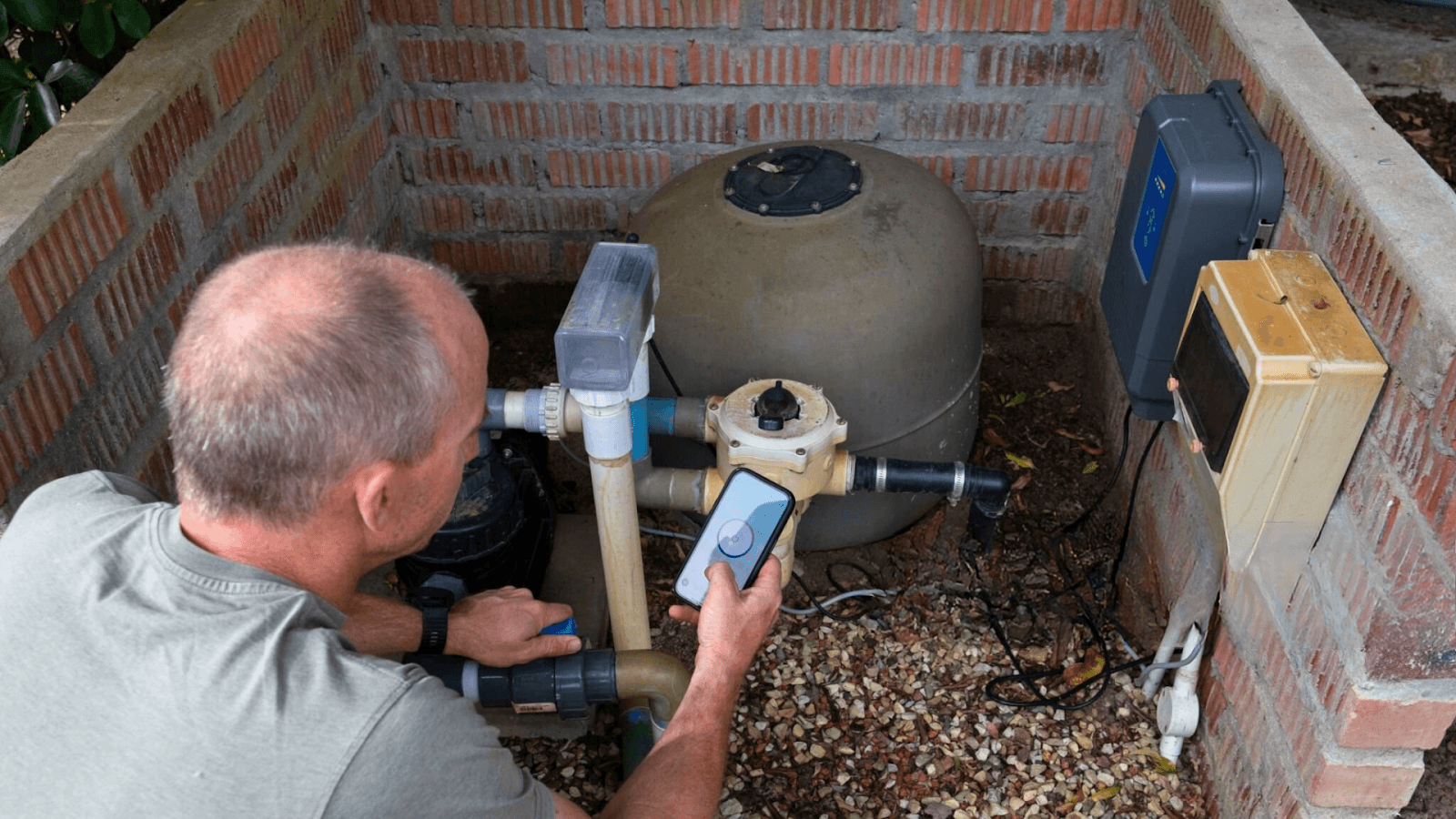 A technician performing maintenance on a smart pool, checking automated cleaning systems.