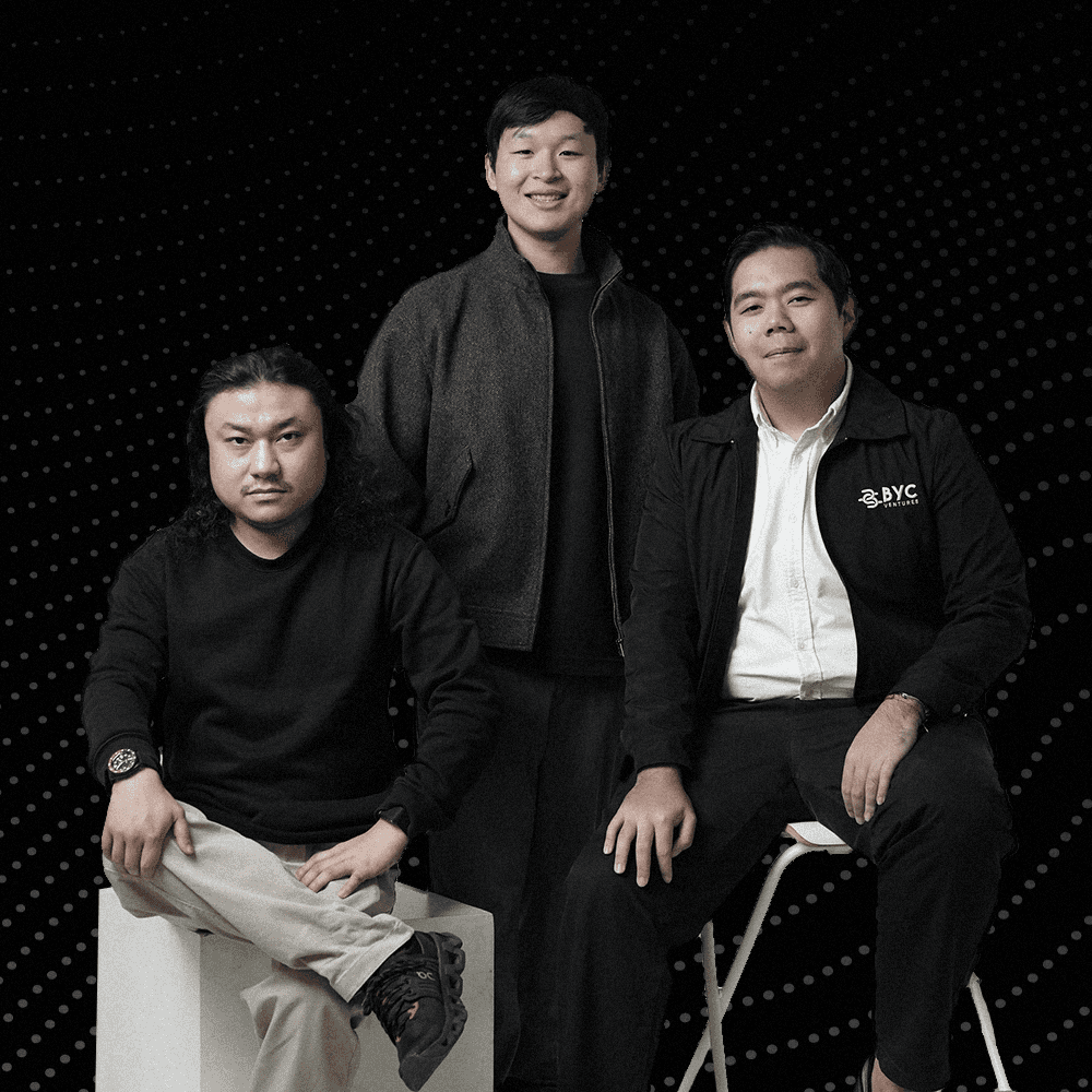 Hand holding a smartphone with a blank screen against a dark background.